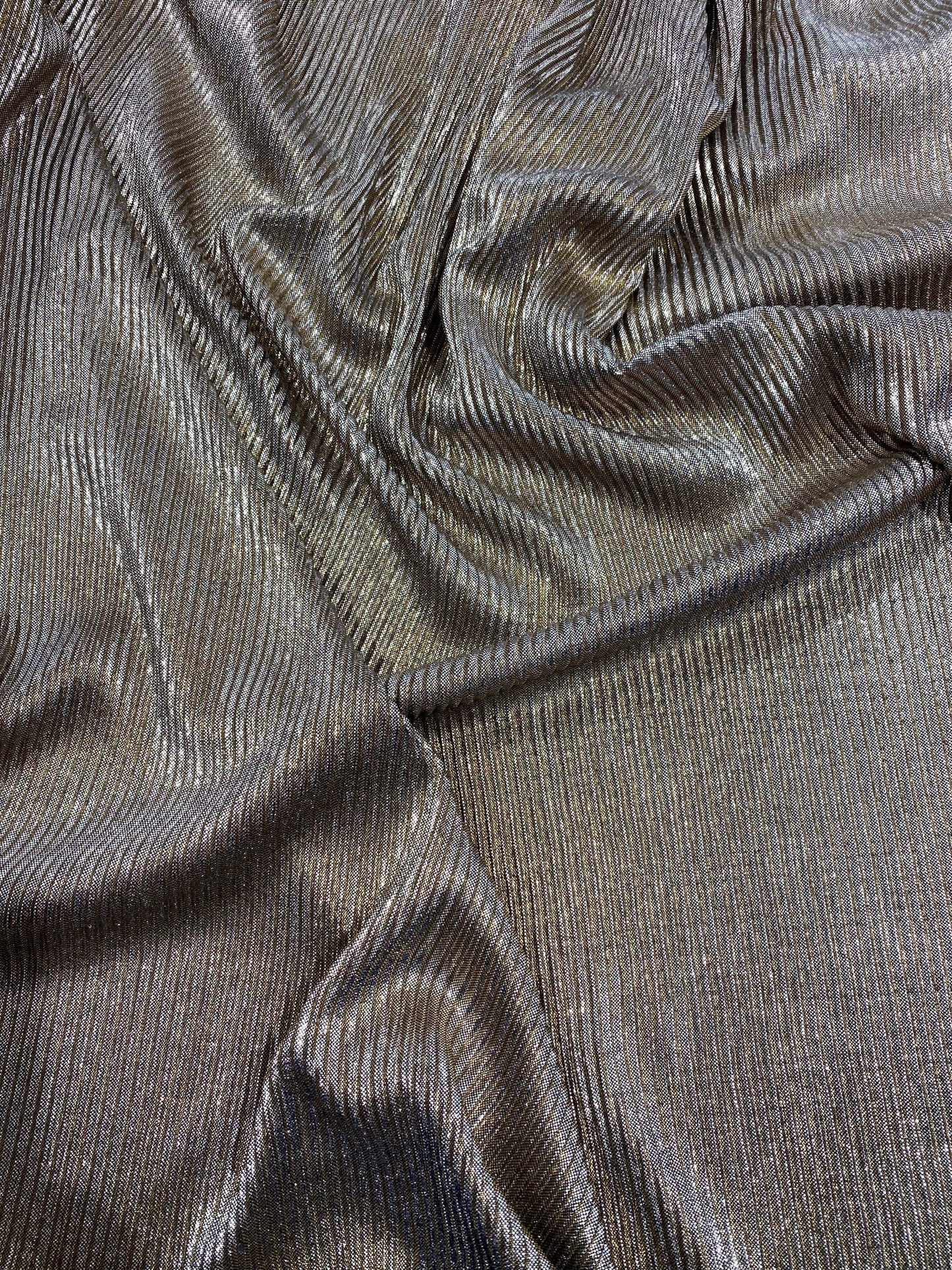New metallic poly pleated black/gold medium weight fabric 2-way stretch 58/60” Sold by the YD. Ships worldwide from Los Angeles CA USA.