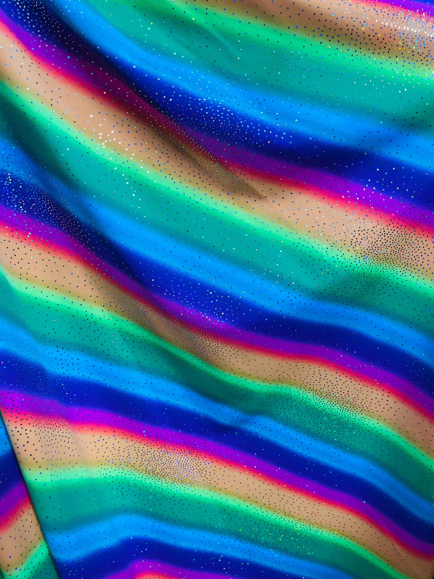 New Rainbow design with sparkling foil it glows in the dark best quality of nylon spandex 4-way stretch 58/60” Sold by the YD.