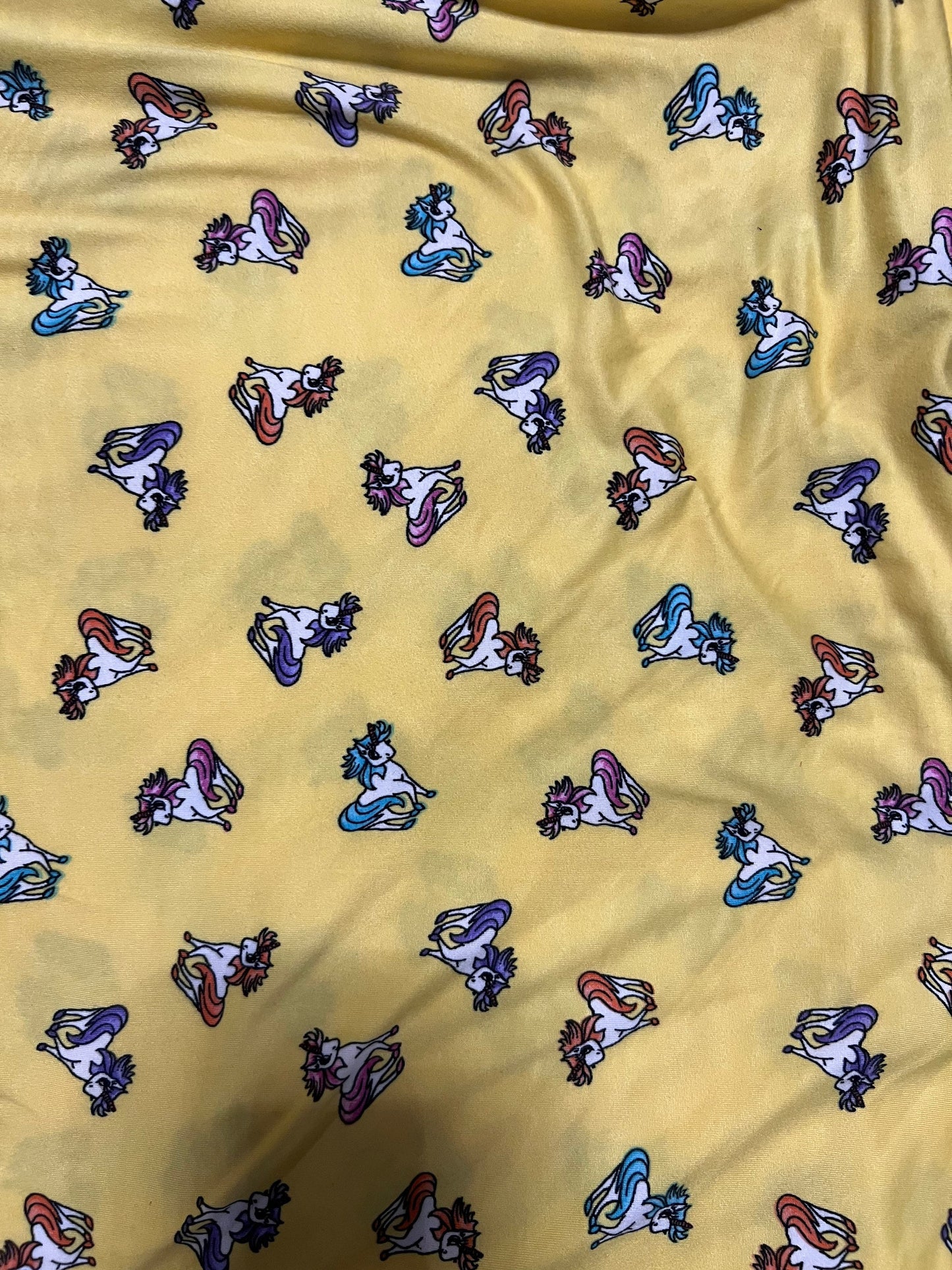 Little Pony design print on light weight poly spandex 4-way stretch yellow/multicolor 58/60” Sold by the YD.