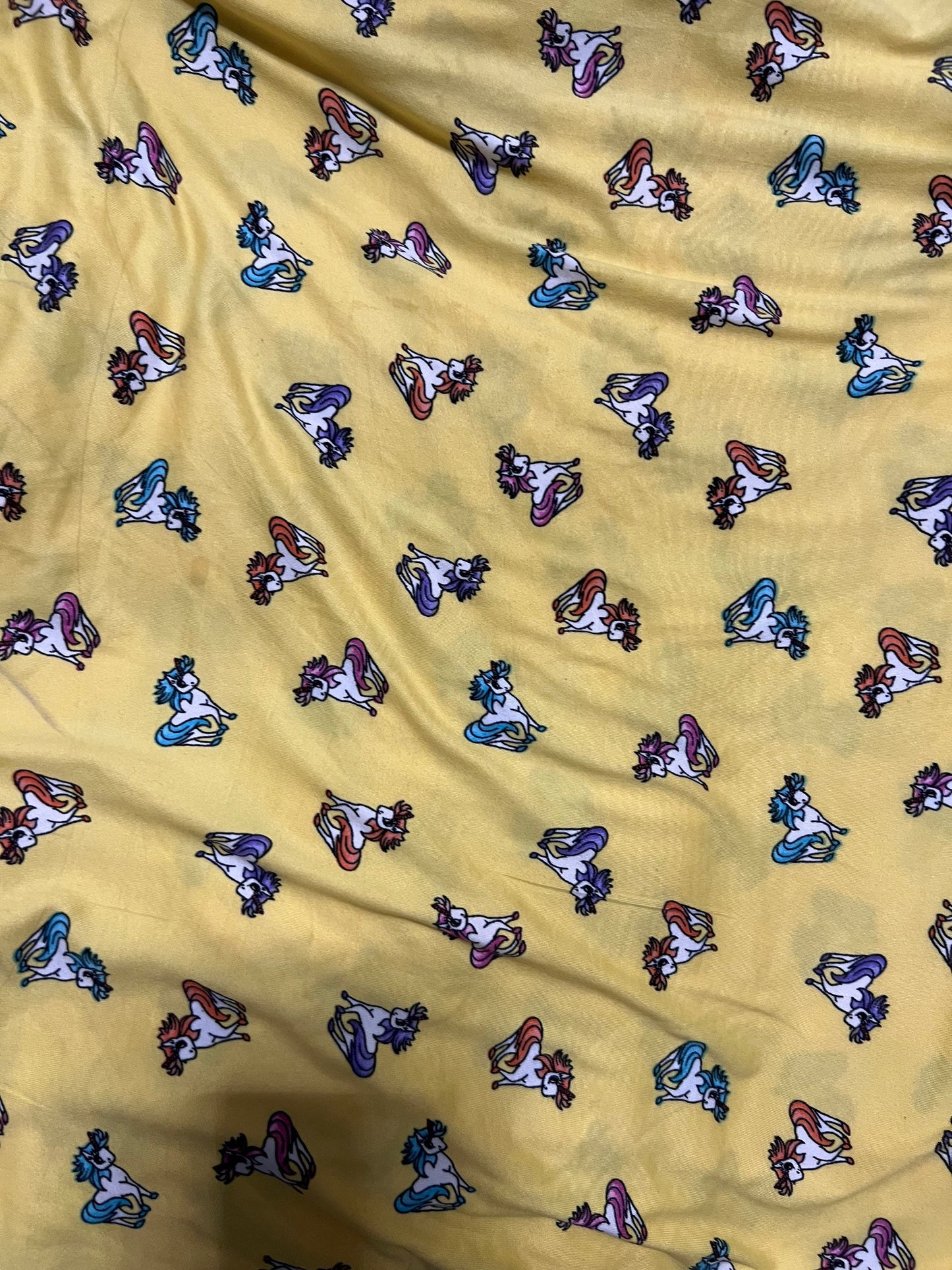 Little Pony design print on light weight poly spandex 4-way stretch yellow/multicolor 58/60” Sold by the YD.