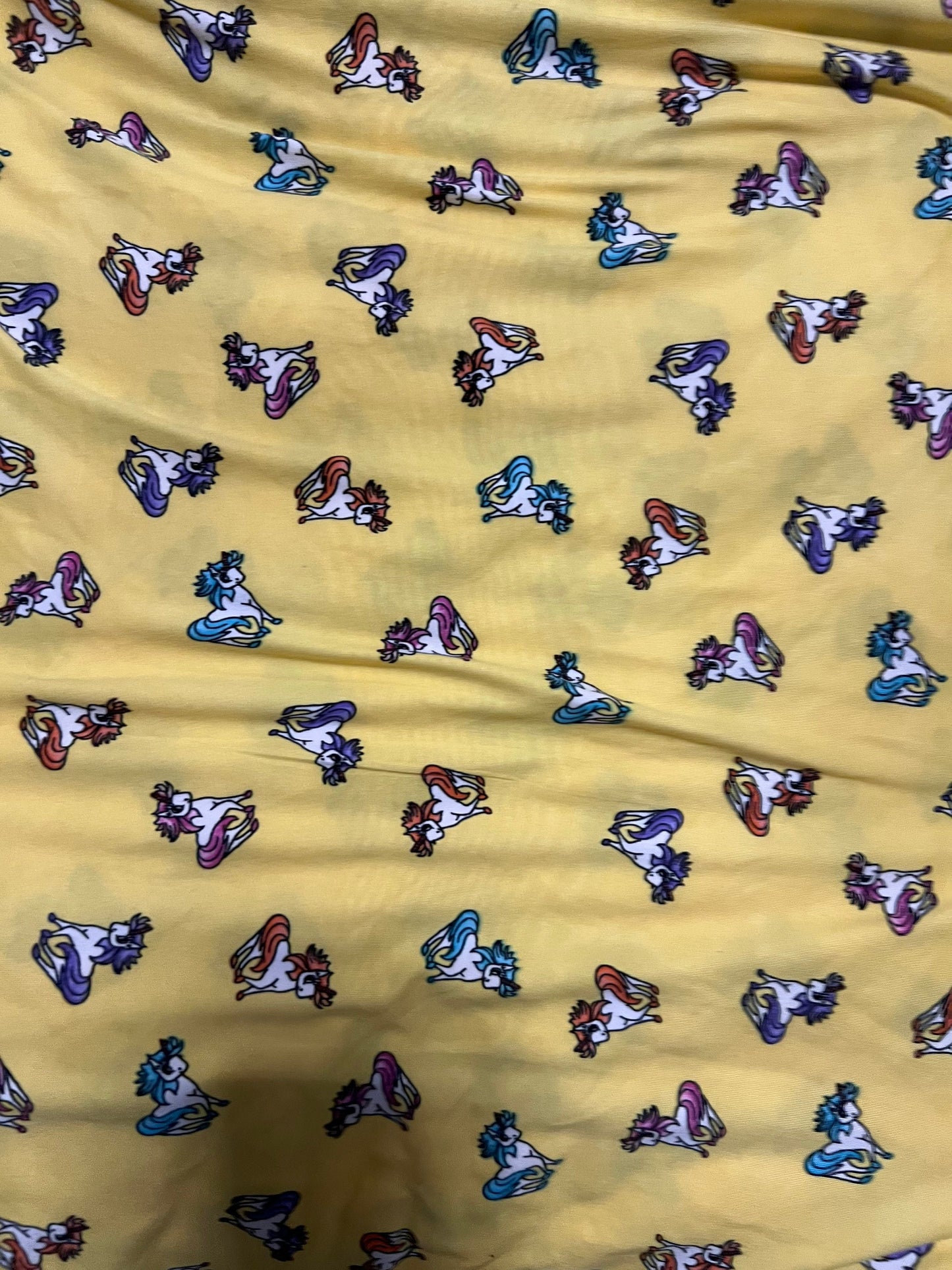 Little Pony design print on light weight poly spandex 4-way stretch yellow/multicolor 58/60” Sold by the YD.