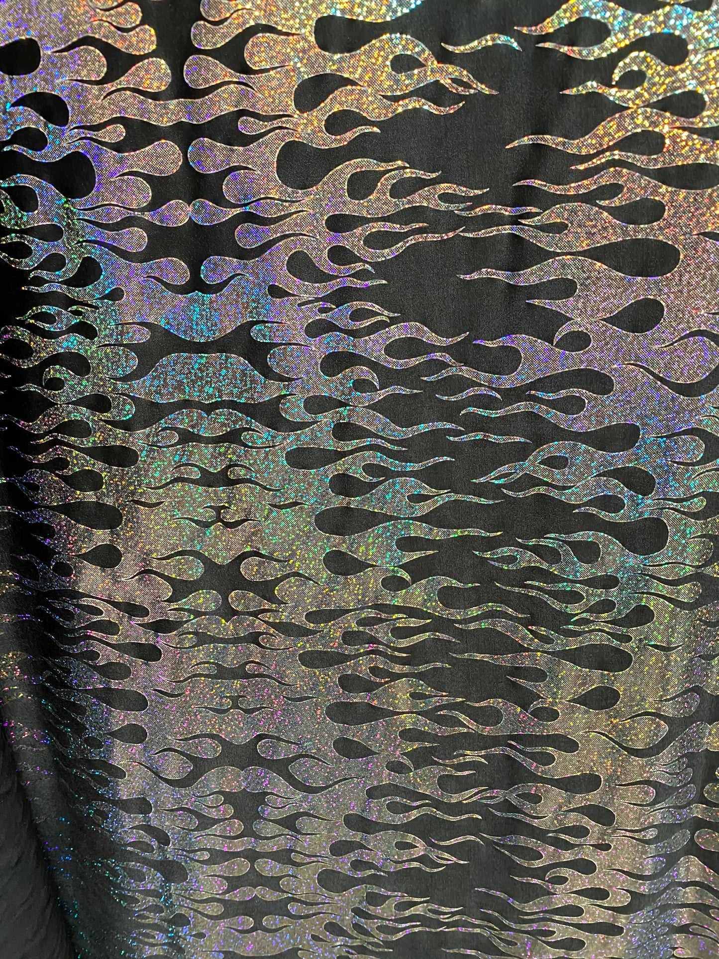 New hologram flames design metallic poly spandex black/silver 2-way stretch 58/60” Sold by the YD. Ships worldwide from Los Angeles CA USA.
