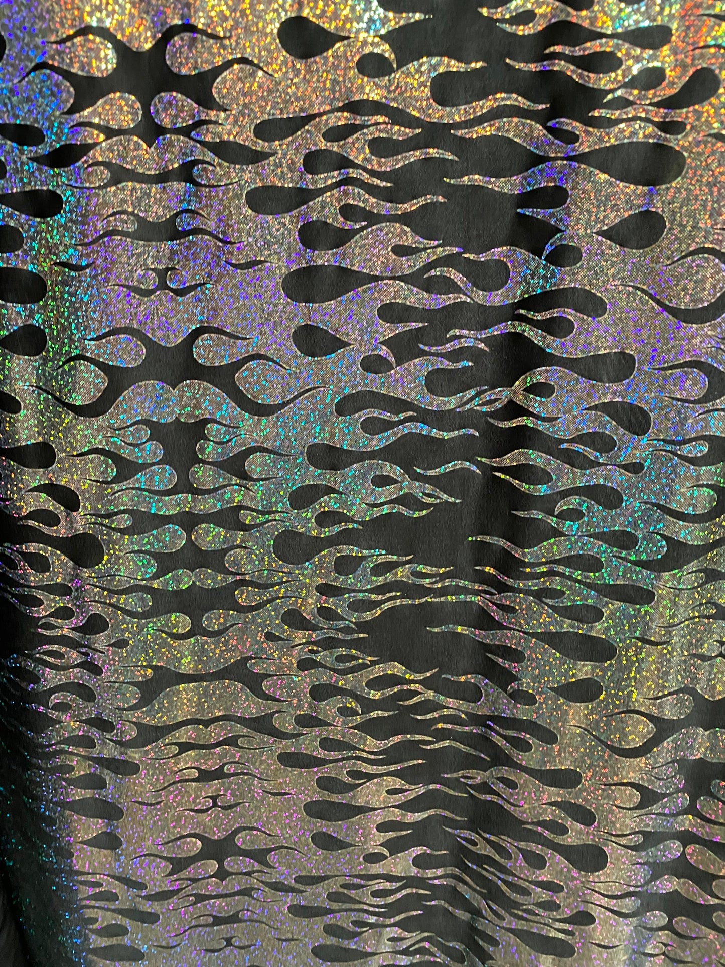 New hologram flames design metallic poly spandex black/silver 2-way stretch 58/60” Sold by the YD. Ships worldwide from Los Angeles CA USA.