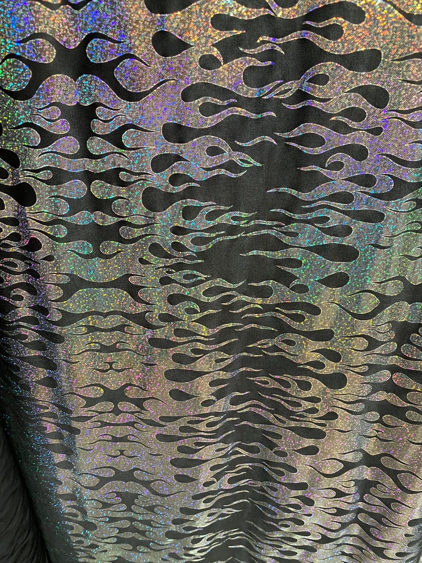 New hologram flames design metallic poly spandex black/silver 2-way stretch 58/60” Sold by the YD. Ships worldwide from Los Angeles CA USA.