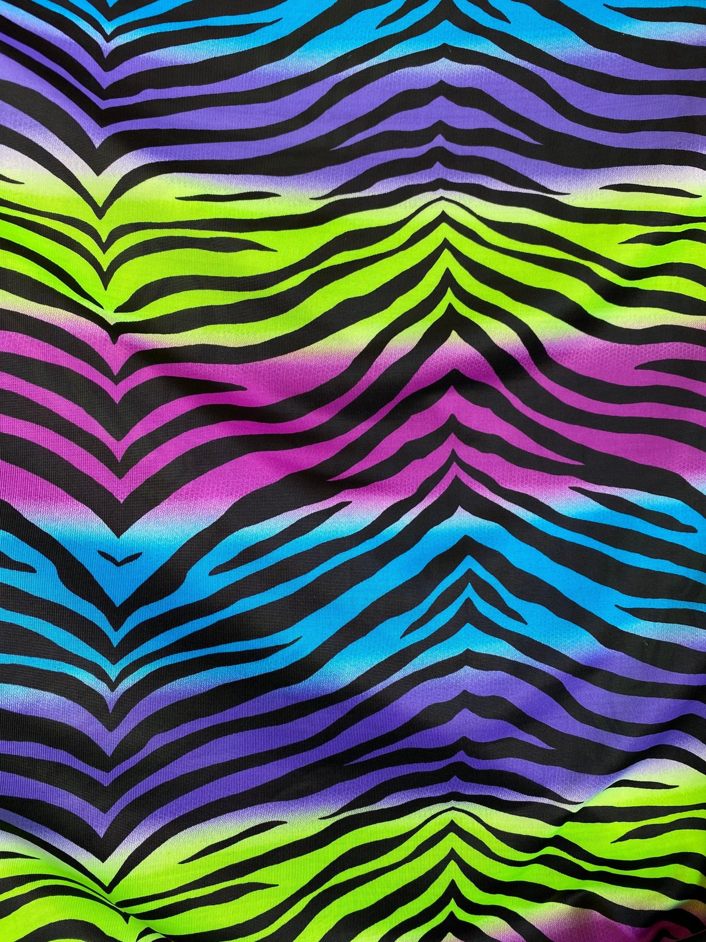 New zebra design rainbow neon green multi poly spandex 4-way stretch medium weight 58/60” Sold by the YD. Ships worldwide from Los Angeles