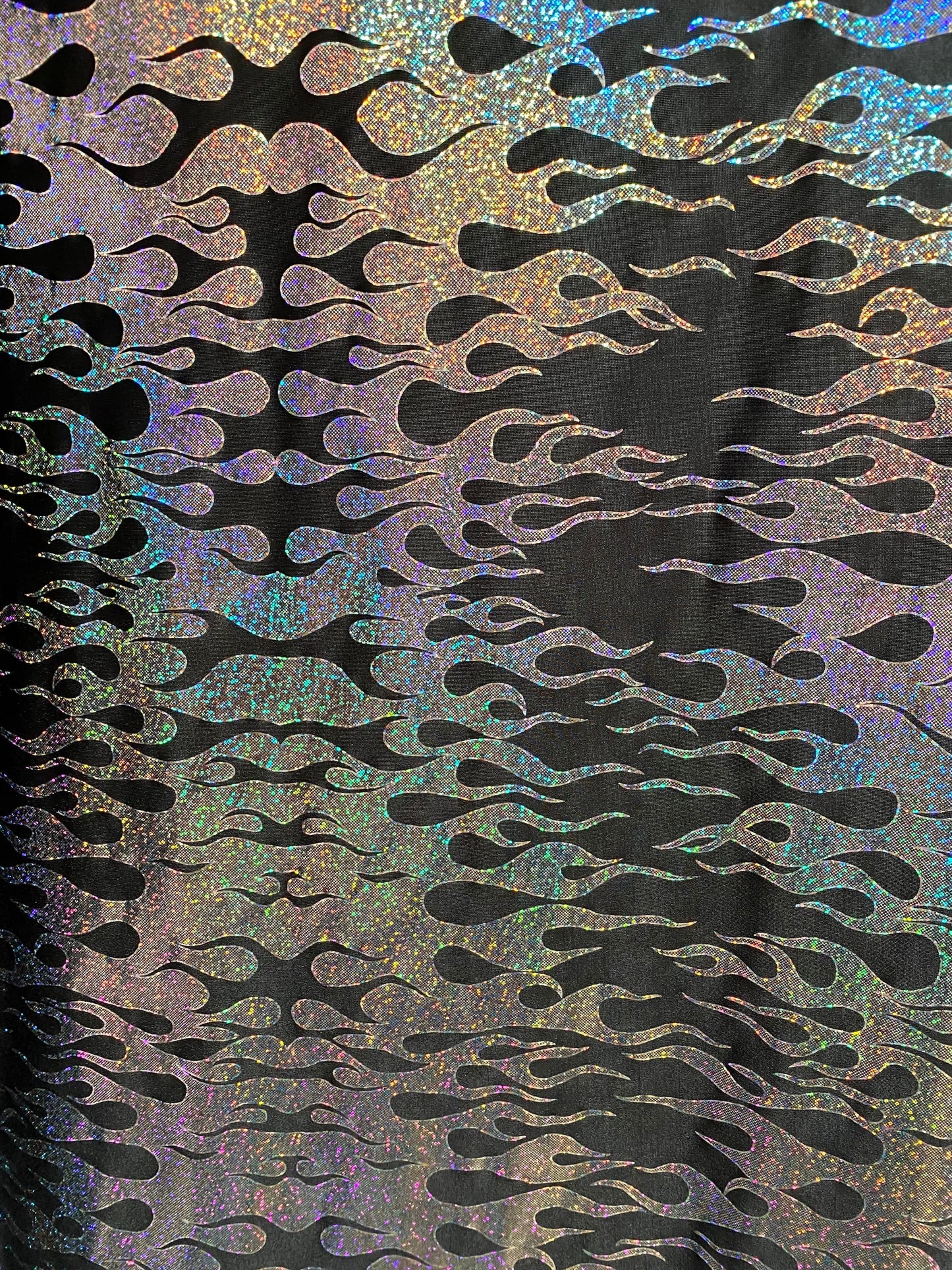 New hologram flames design metallic poly spandex black/silver 2-way stretch 58/60” Sold by the YD. Ships worldwide from Los Angeles CA USA.