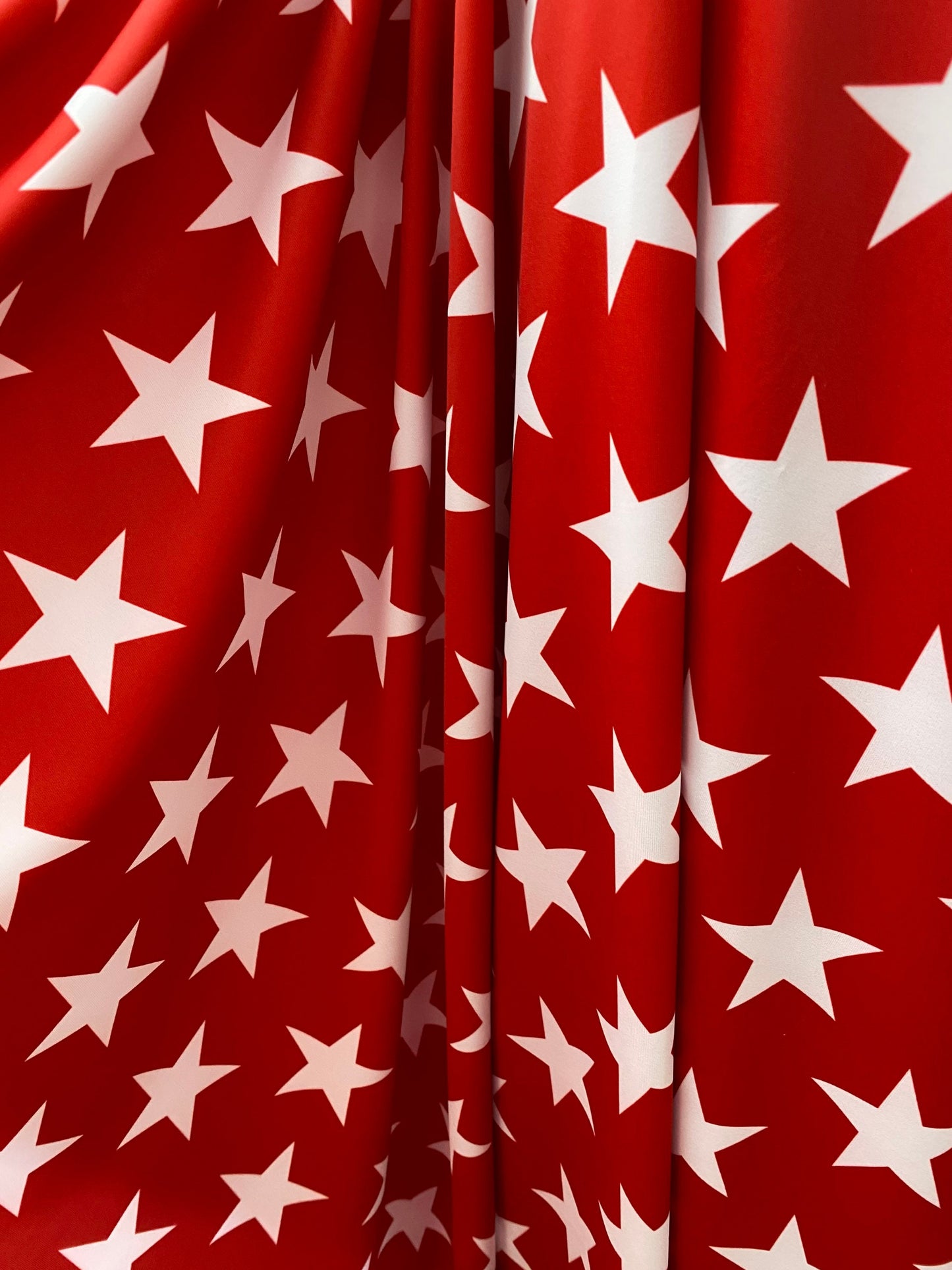 New stars design red/white print on nylon spandex 4-way Stretch 58/60” Sold by the YD. Ships worldwide from Los Angeles California USA.
