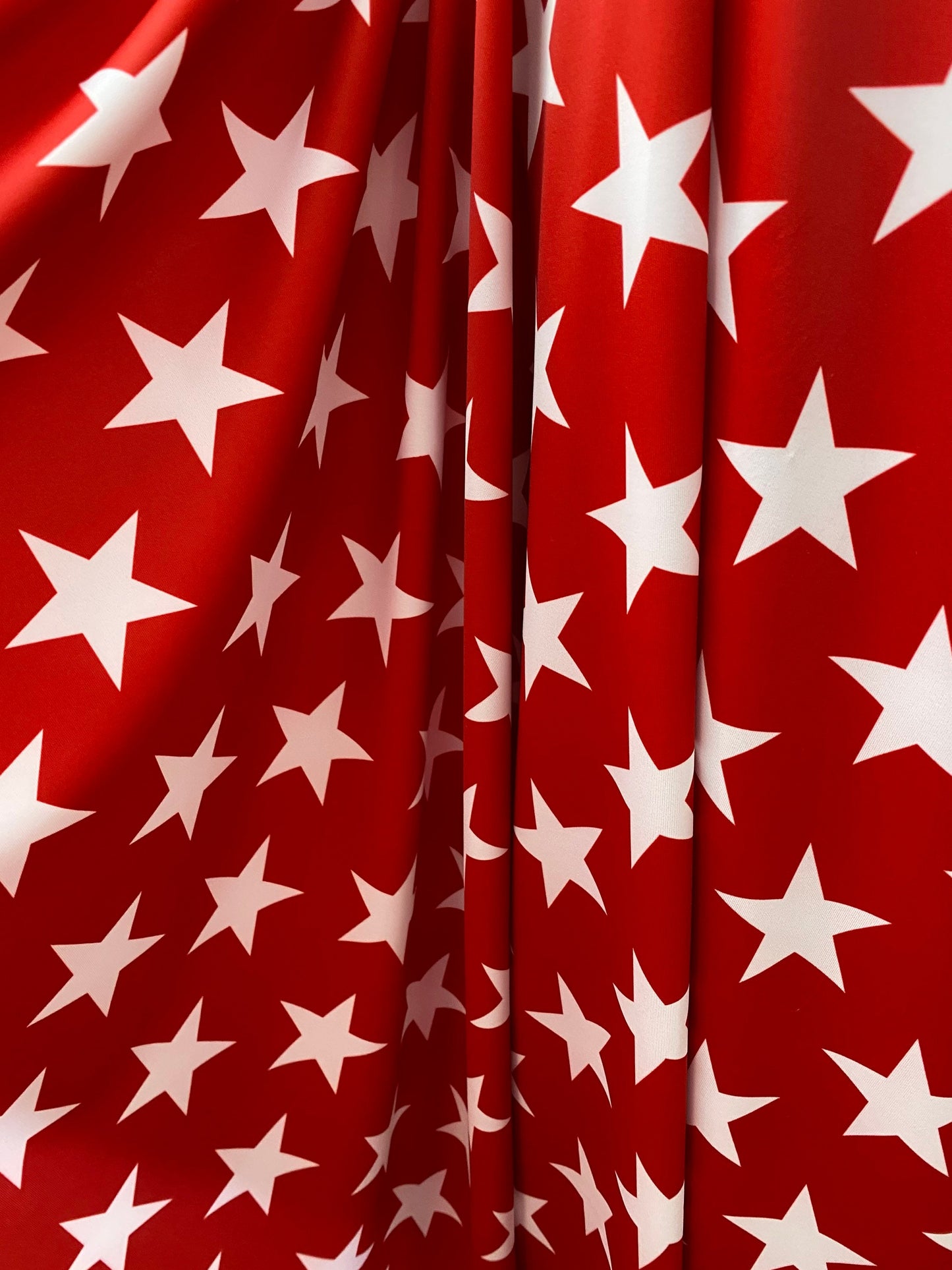 New stars design red/white print on nylon spandex 4-way Stretch 58/60” Sold by the YD. Ships worldwide from Los Angeles California USA.