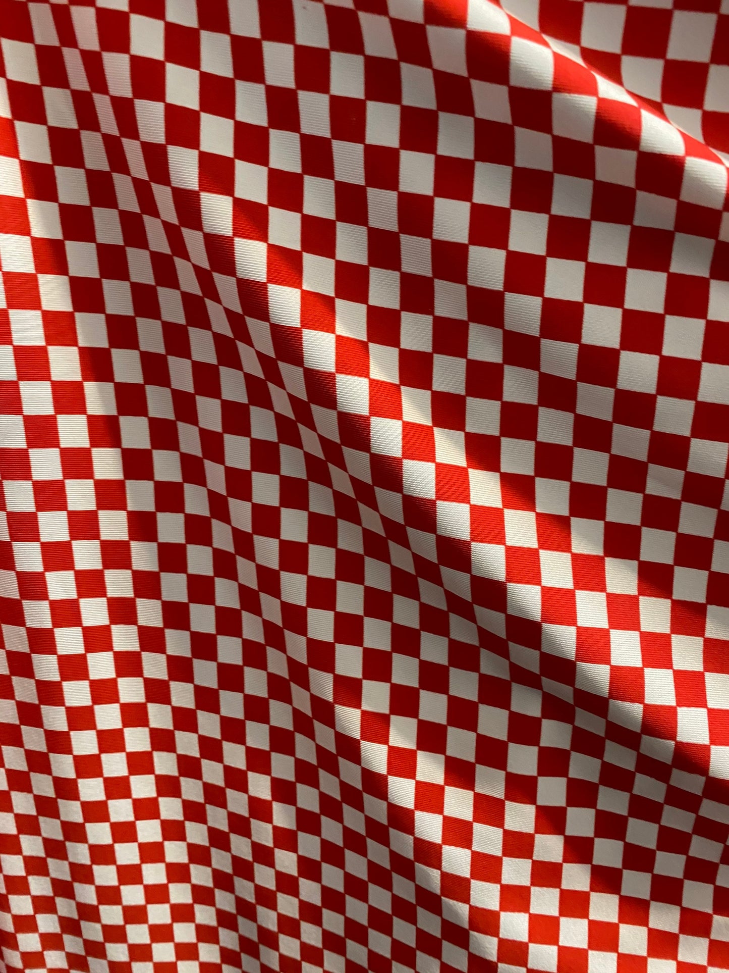 New small Chequers design red/white print on poly spandex 4-way stretch 58/60” Sold by the YD. Ships worldwide from Los Angeles California