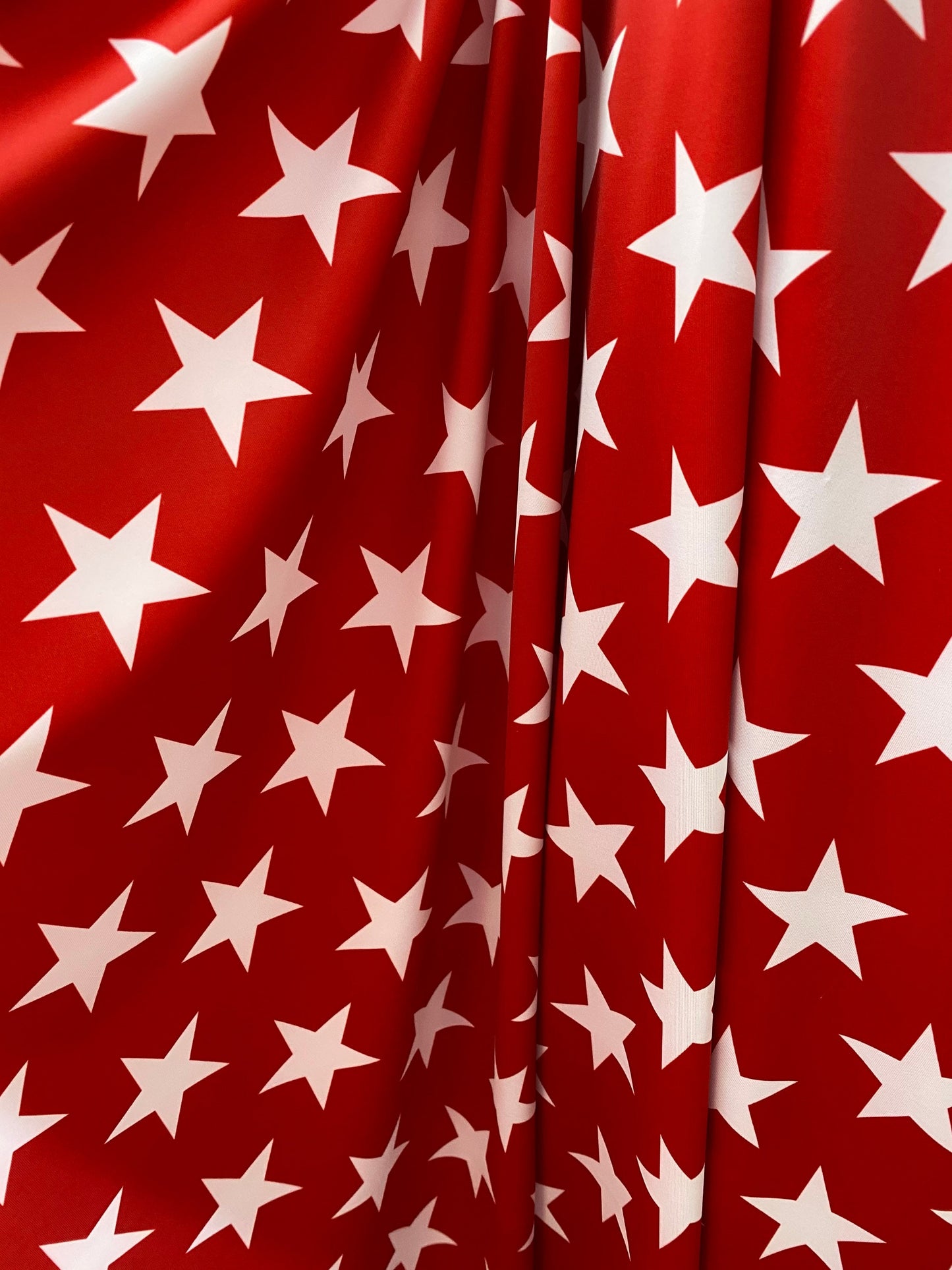 New stars design red/white print on nylon spandex 4-way Stretch 58/60” Sold by the YD. Ships worldwide from Los Angeles California USA.