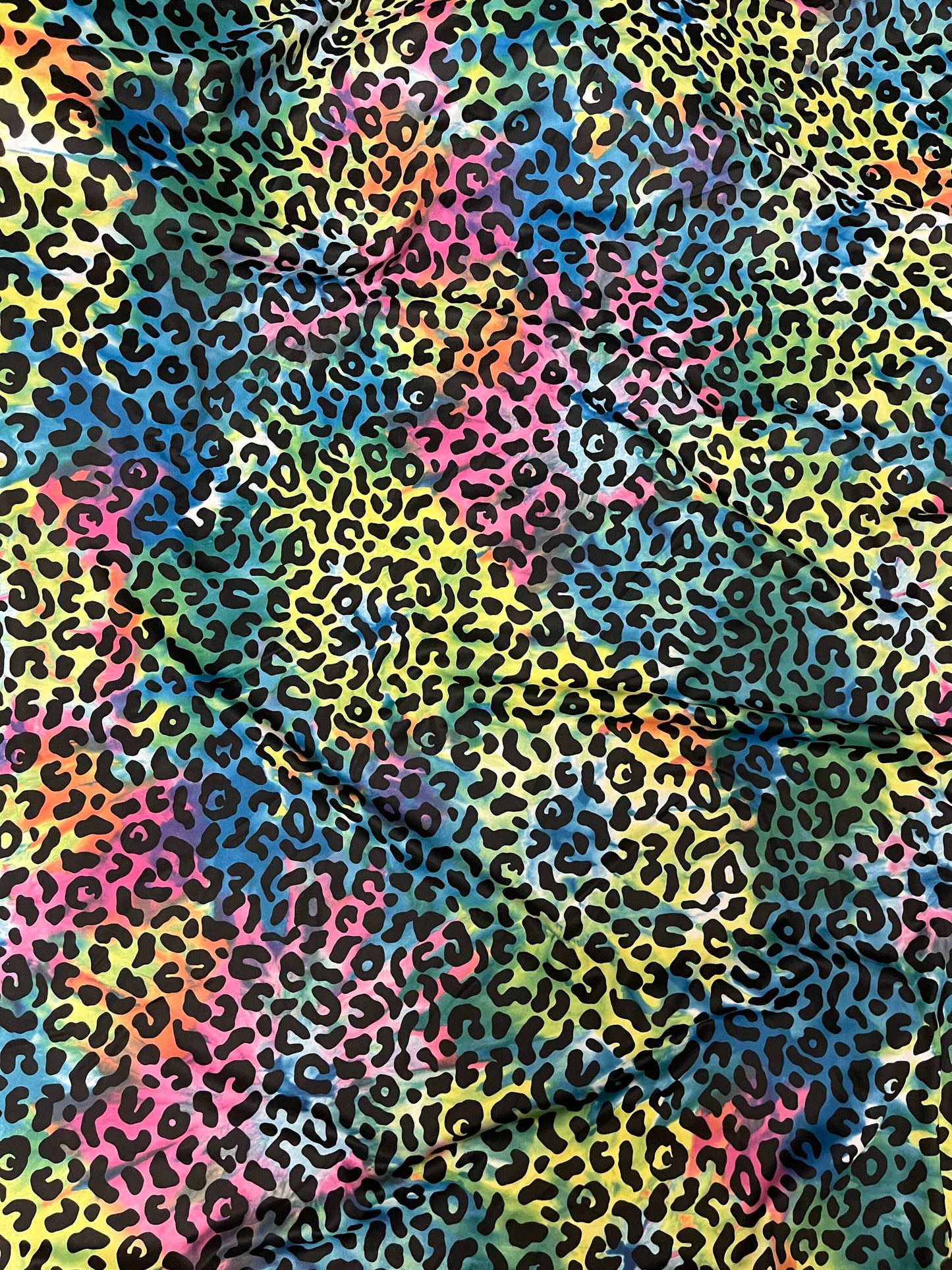 Exotic leopard design print on tie dye nylon spandex 4-way stretch 58/60” Sold by the YD. Ships Worldwide from Los Angeles California USA.