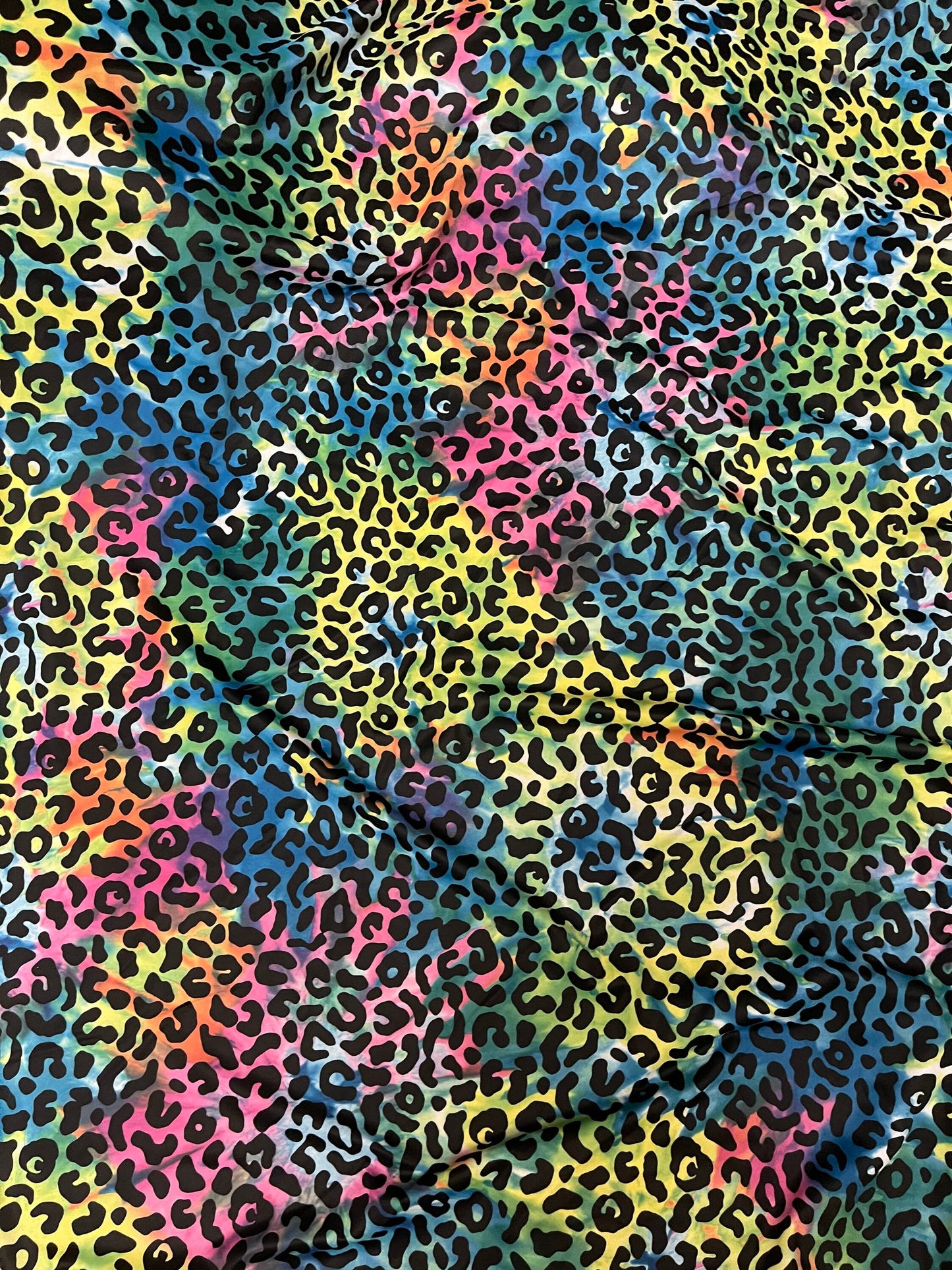Exotic leopard design print on tie dye nylon spandex 4-way stretch 58/60” Sold by the YD. Ships Worldwide from Los Angeles California USA.
