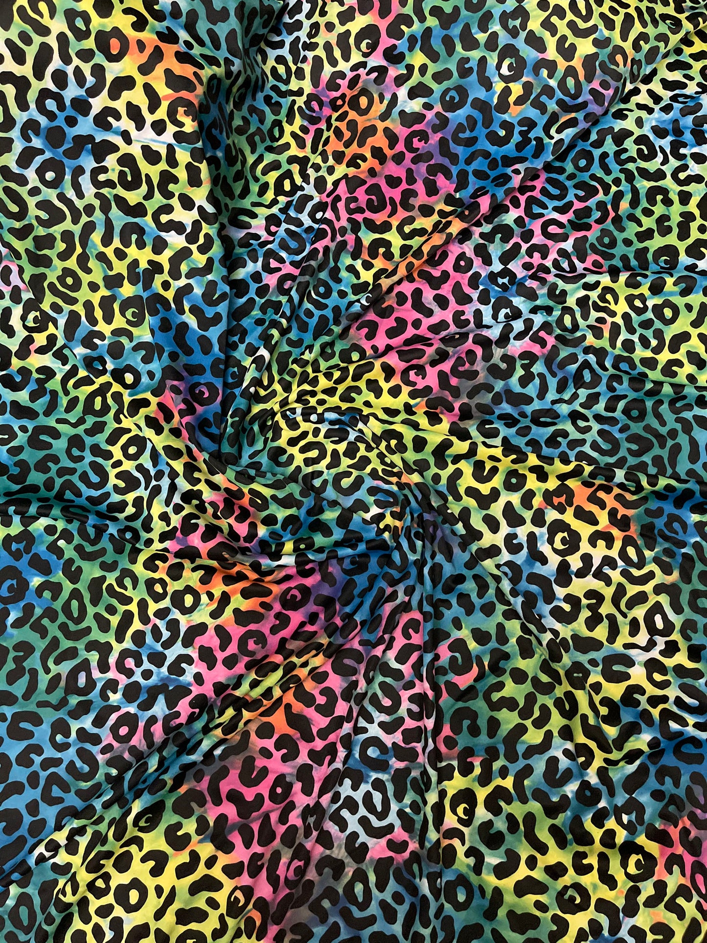Exotic leopard design print on tie dye nylon spandex 4-way stretch 58/60” Sold by the YD. Ships Worldwide from Los Angeles California USA.