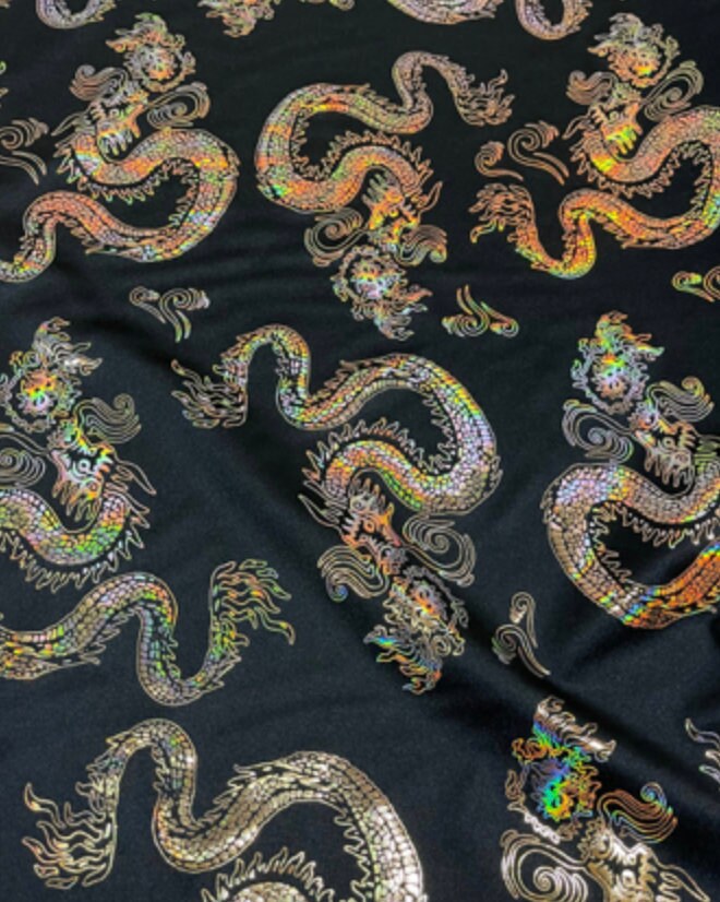 New Dragon design print on metallic nylon spandex Black Iridescent gold 4-way stretch spandex 58/60” Sold by the YD. Ships worldwide