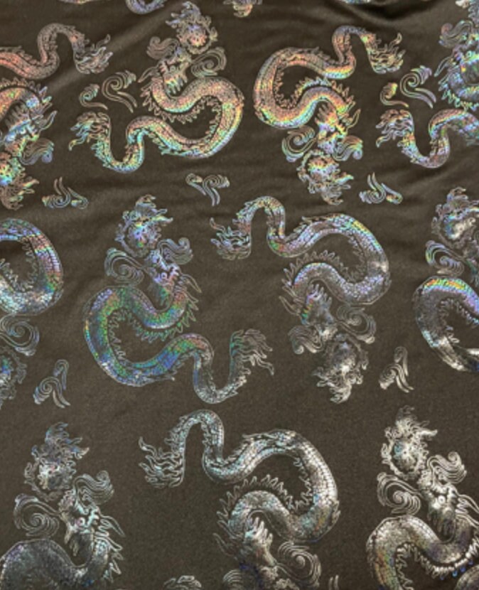 New Dragon design print on metallic nylon spandex Black Iridescent black 4-way stretch spandex 58/60” Sold by the YD. Ships worldwide