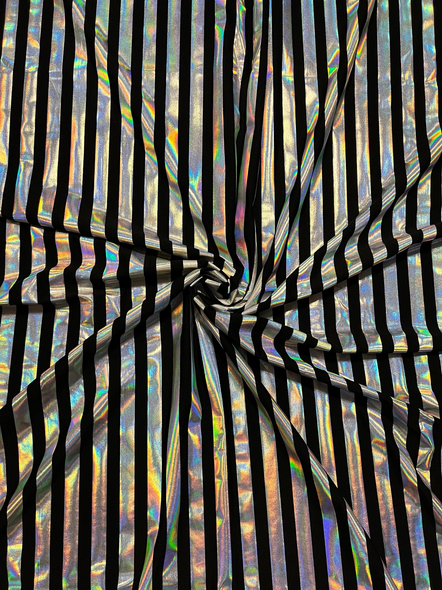 Metallic stripe design black/iridescent silver poly spandex 2-way stretch with lacer foil 58/60” Sold by the YD. Ships Worldwide from L.A CA