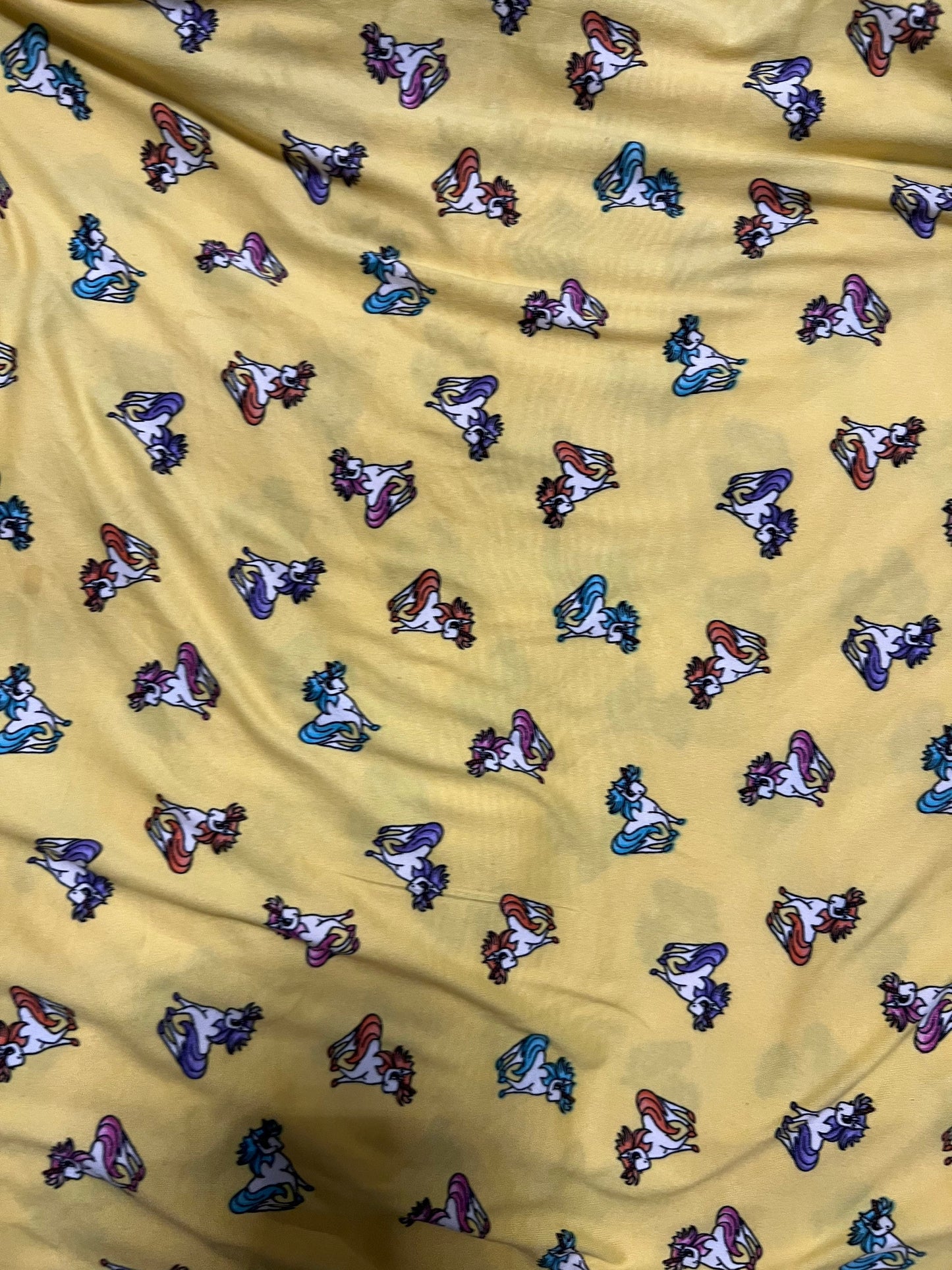 Little Pony design print on light weight poly spandex 4-way stretch yellow/multicolor 58/60” Sold by the YD.