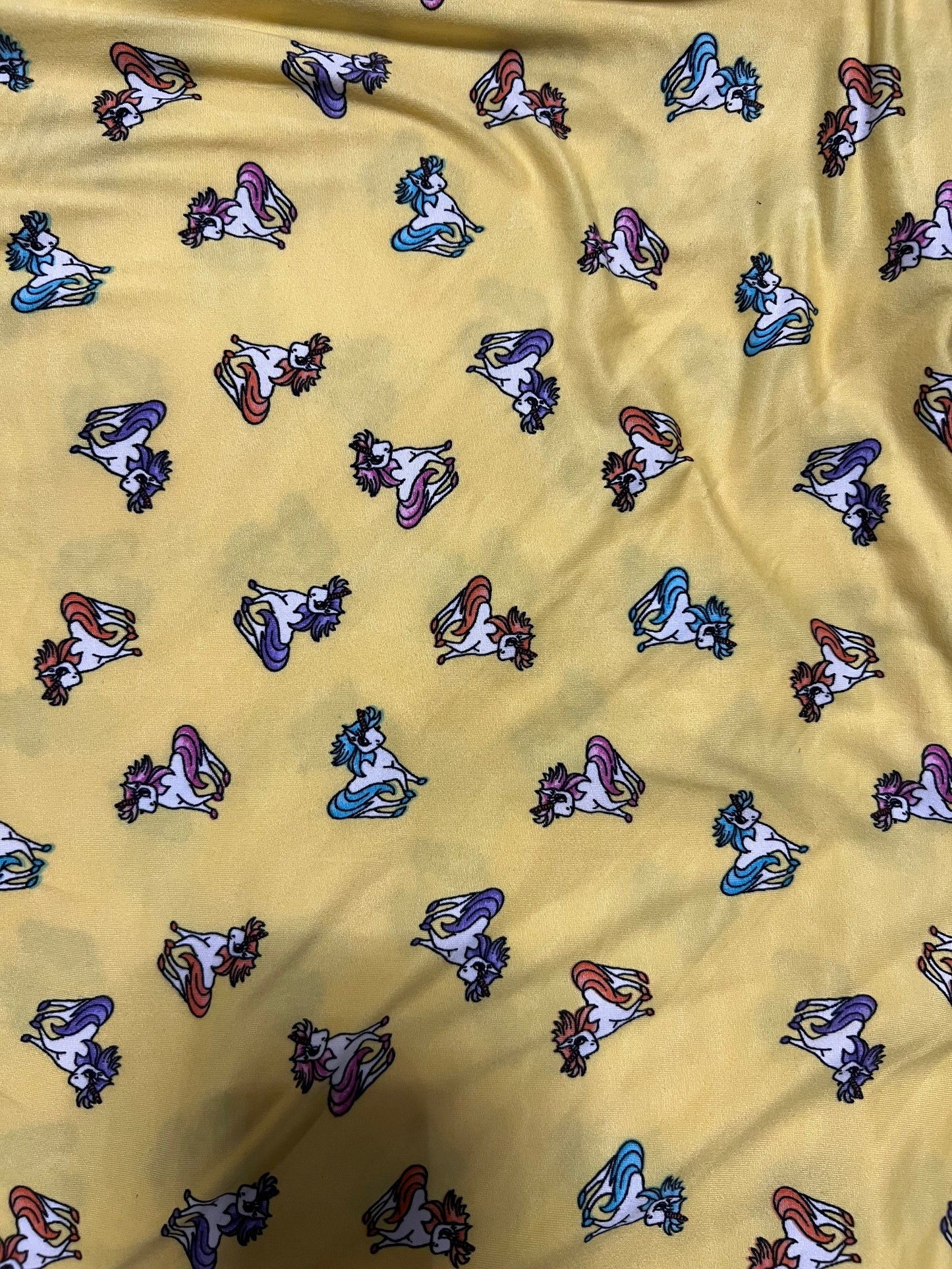 Little Pony design print on light weight poly spandex 4-way stretch yellow/multicolor 58/60” Sold by the YD.