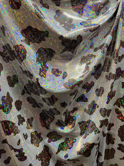 Cow design w/silver/Black & w/silver/brown on shattered glass New metallic hologram nylon spandex 4-way stretch 58/60” Sold by the YD.