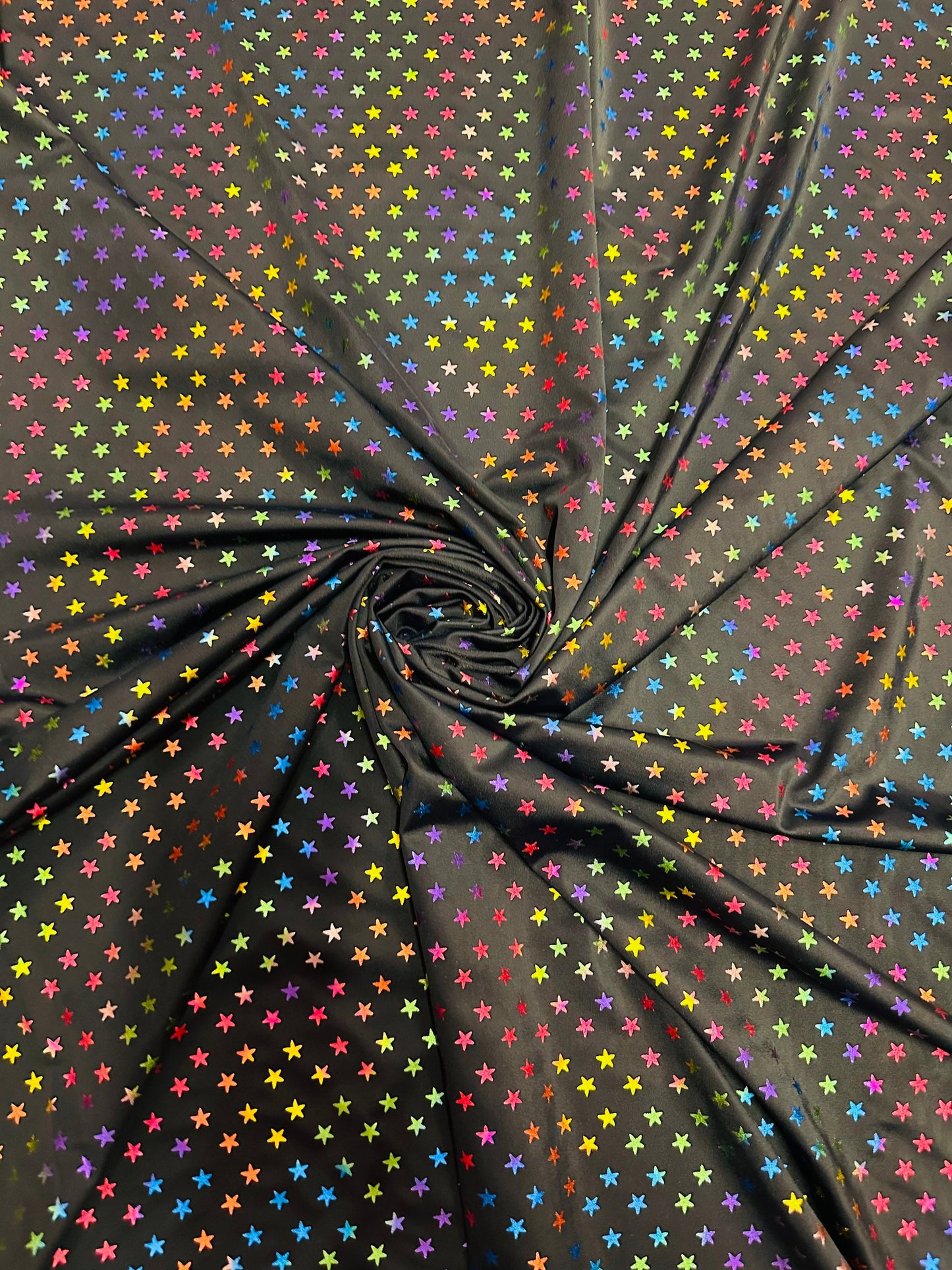 Stars multicolor design black/rainbow print on best quality of nylon spandex 4-way stretch 58/60” Sold by the YD.