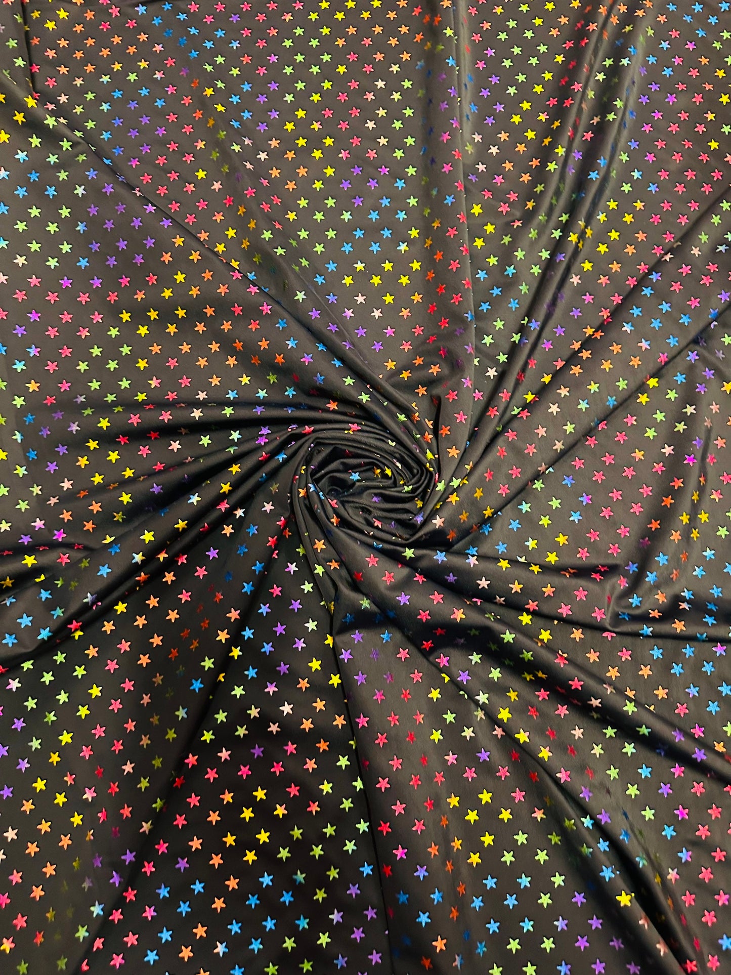 Stars multicolor design black/rainbow print on best quality of nylon spandex 4-way stretch 58/60” Sold by the YD.
