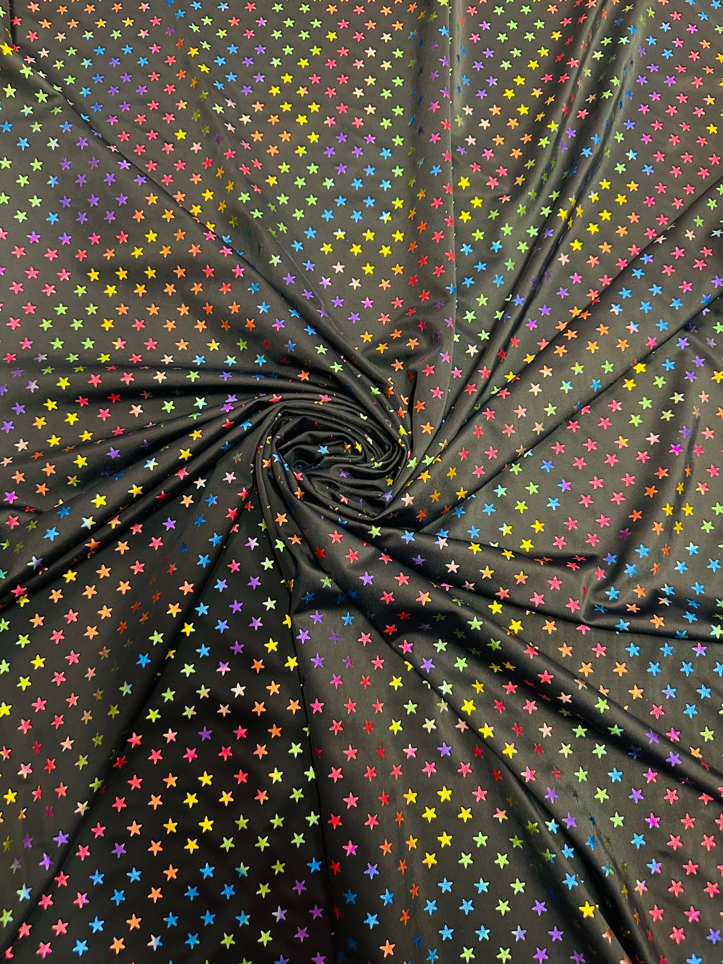 Stars multicolor design black/rainbow print on best quality of nylon spandex 4-way stretch 58/60” Sold by the YD.