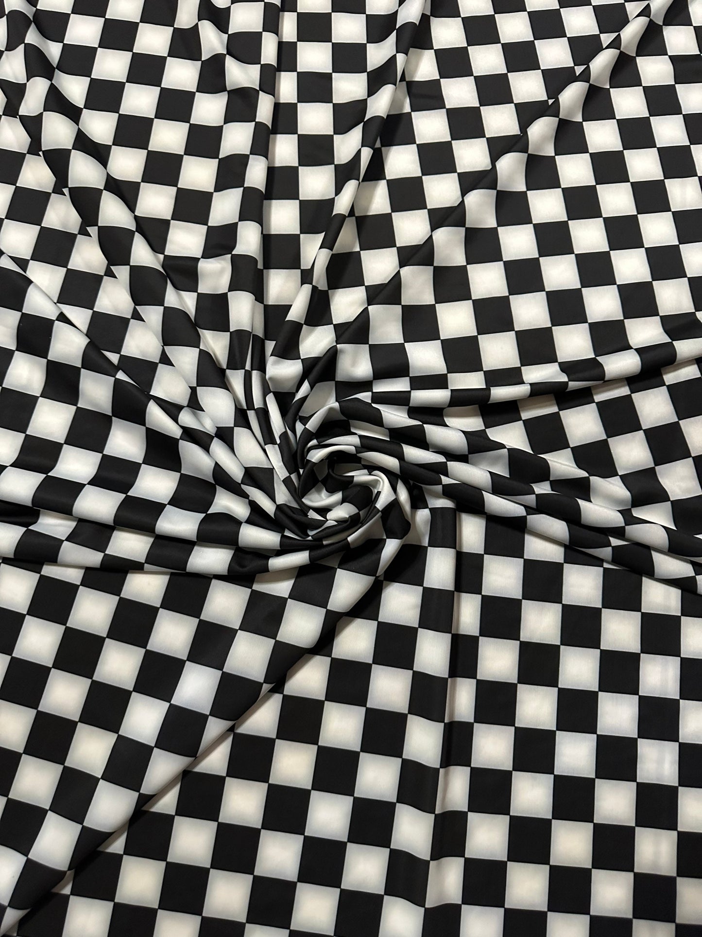 Checkers design 1” size white/black print on great quality of nylon spandex 4-way stretch 58/60” Sold by the YD.