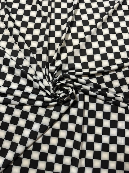 Checkers design 1” size white/black print on great quality of nylon spandex 4-way stretch 58/60” Sold by the YD.
