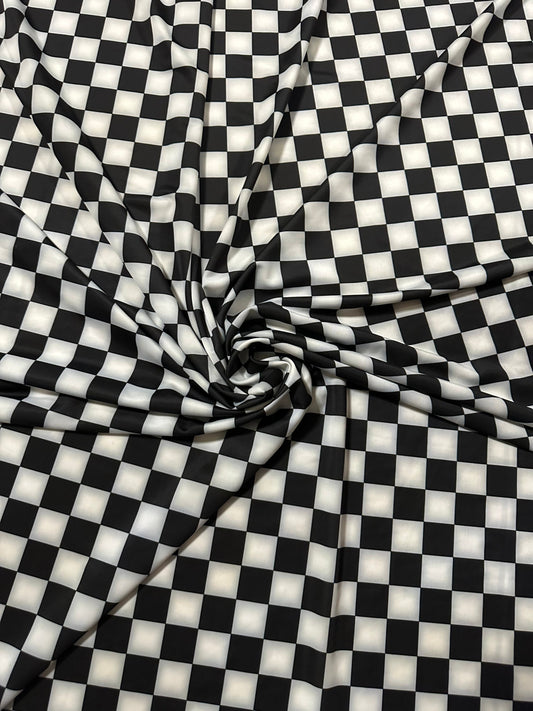 Checkers design 1” size white/black print on great quality of nylon spandex 4-way stretch 58/60” Sold by the YD.