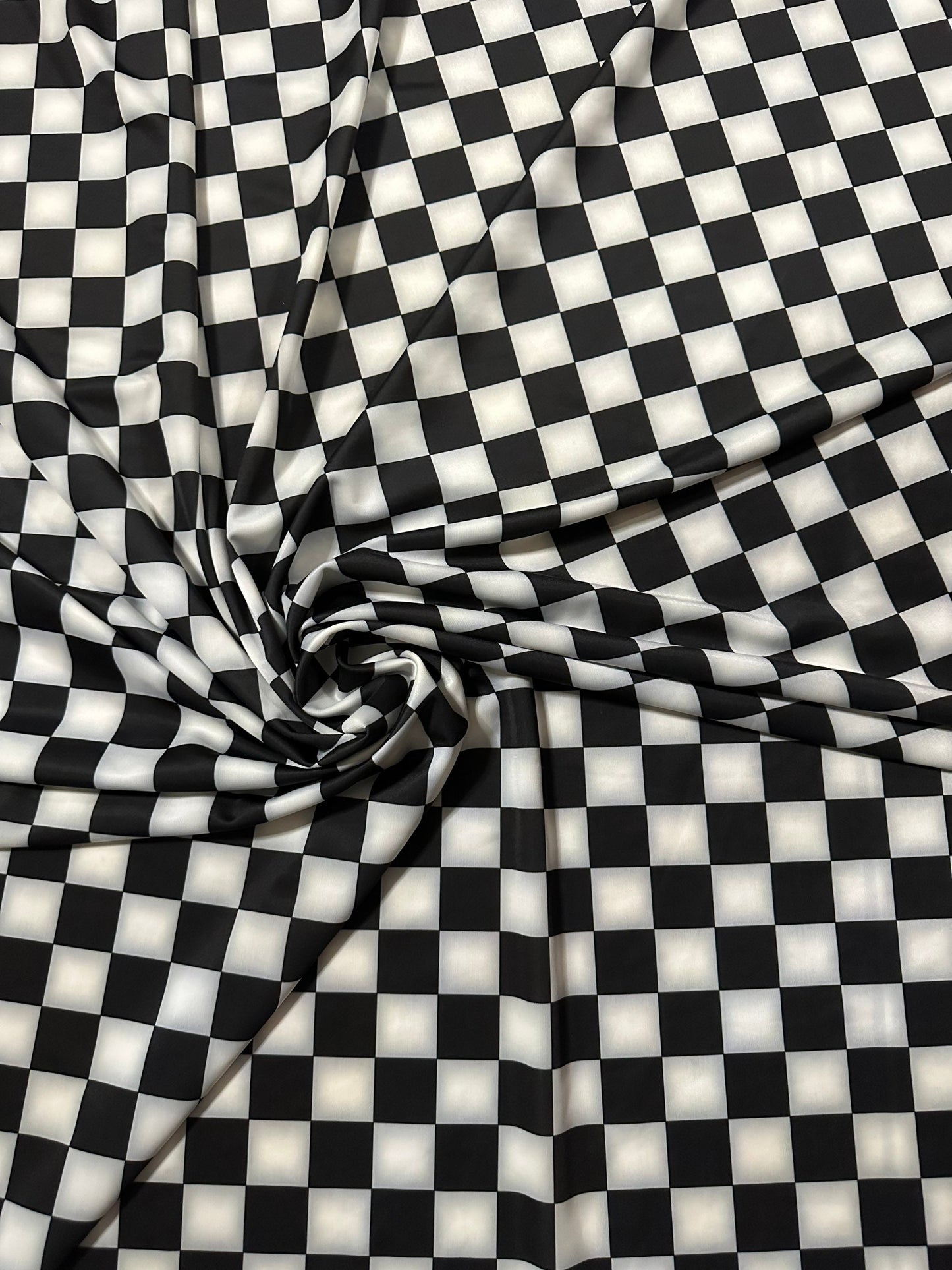 Checkers design 1” size white/black print on great quality of nylon spandex 4-way stretch 58/60” Sold by the YD.