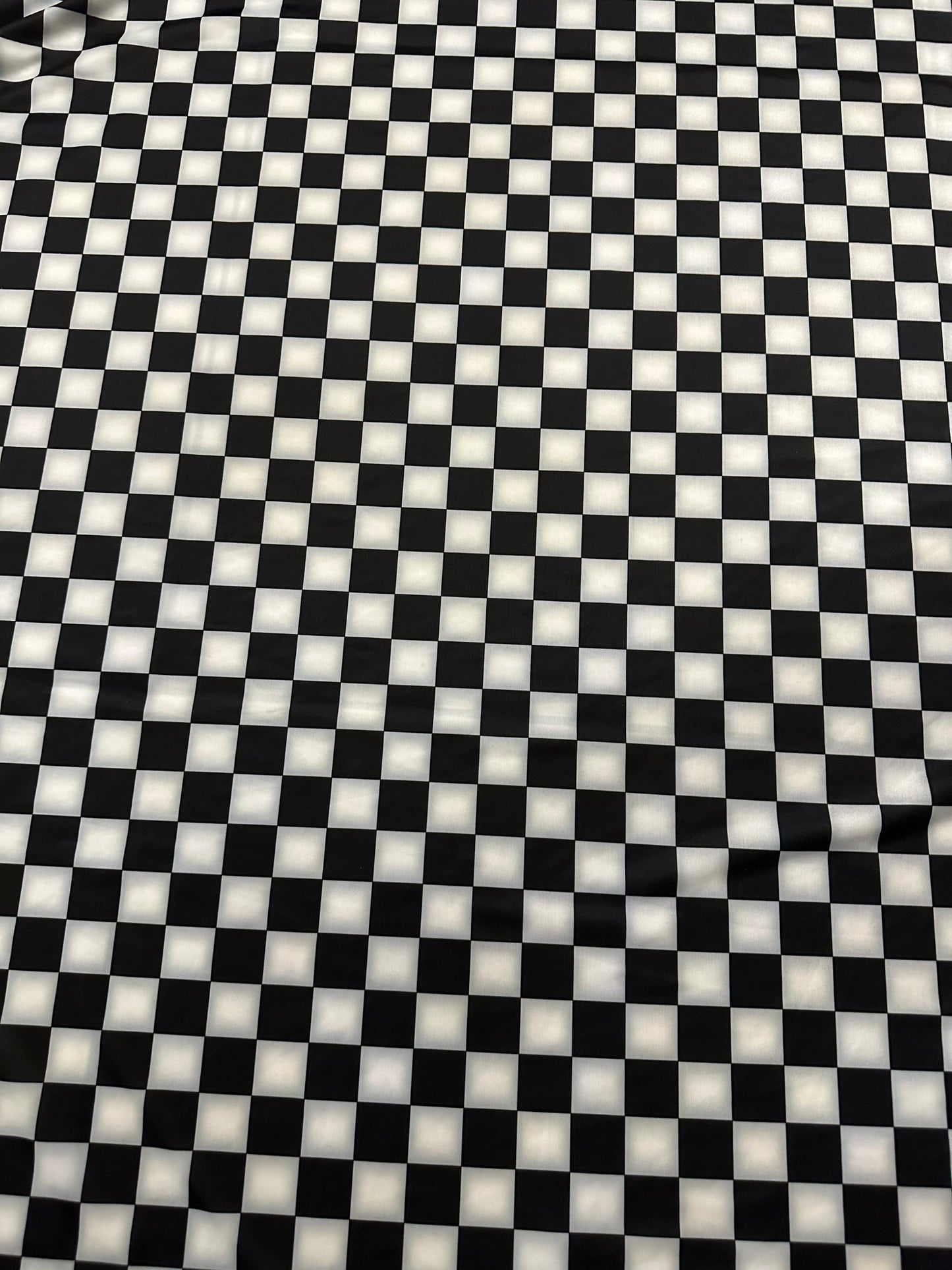 Checkers design 1” size white/black print on great quality of nylon spandex 4-way stretch 58/60” Sold by the YD.