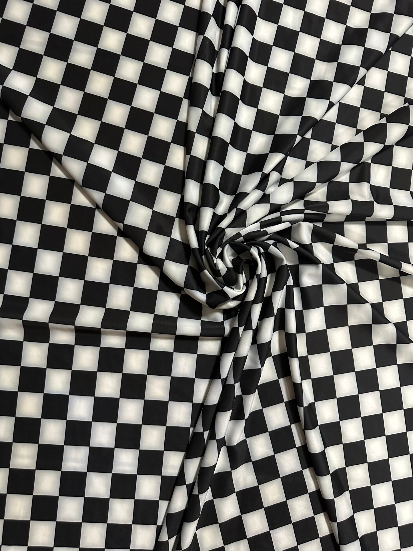Checkers design 1” size white/black print on great quality of nylon spandex 4-way stretch 58/60” Sold by the YD.