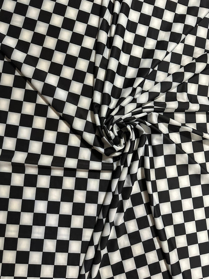 Checkers design 1” size white/black print on great quality of nylon spandex 4-way stretch 58/60” Sold by the YD.