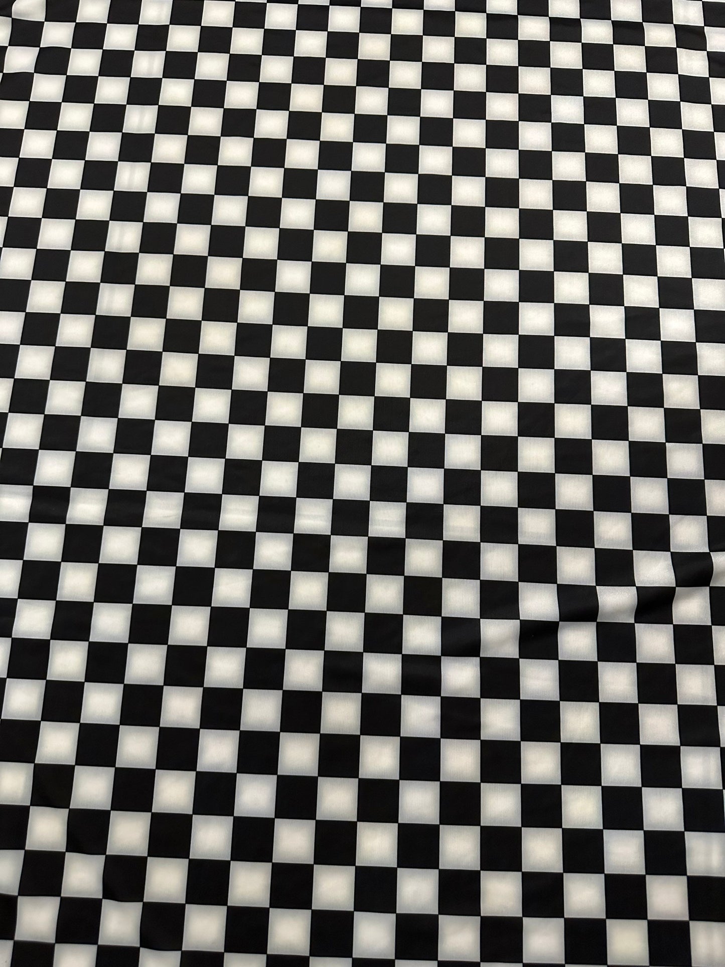 Checkers design 1” size white/black print on great quality of nylon spandex 4-way stretch 58/60” Sold by the YD.