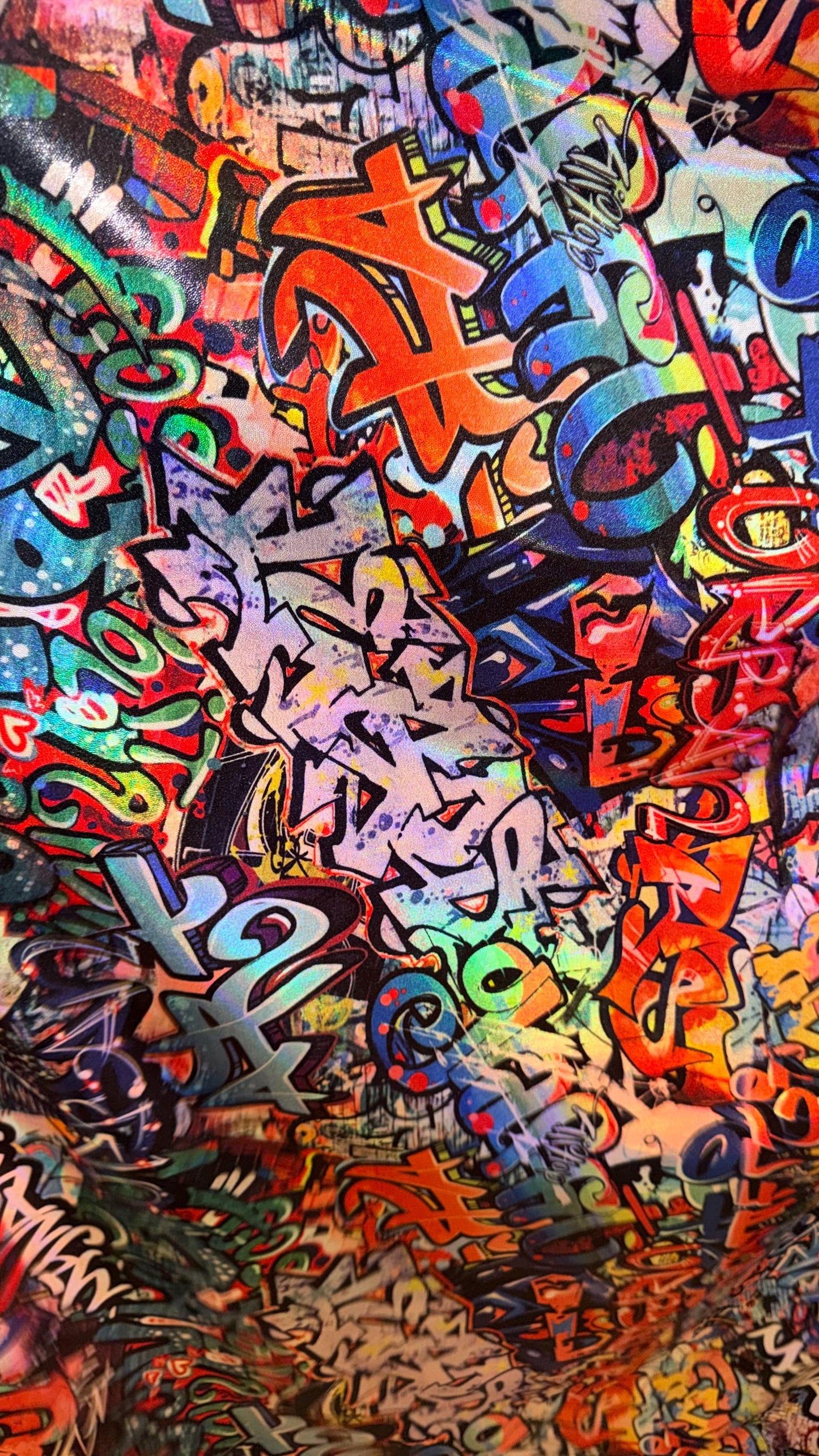 Graffiti design Multicolor on Iridescent metallic hologram nylon spandex  4-way stretch 58/60” Sold by the YD.  High quality fabrics