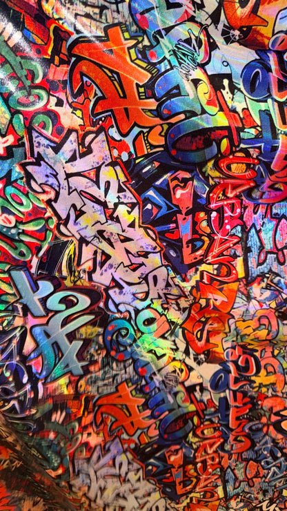 Graffiti design Multicolor on Iridescent metallic hologram nylon spandex  4-way stretch 58/60” Sold by the YD.  High quality fabrics