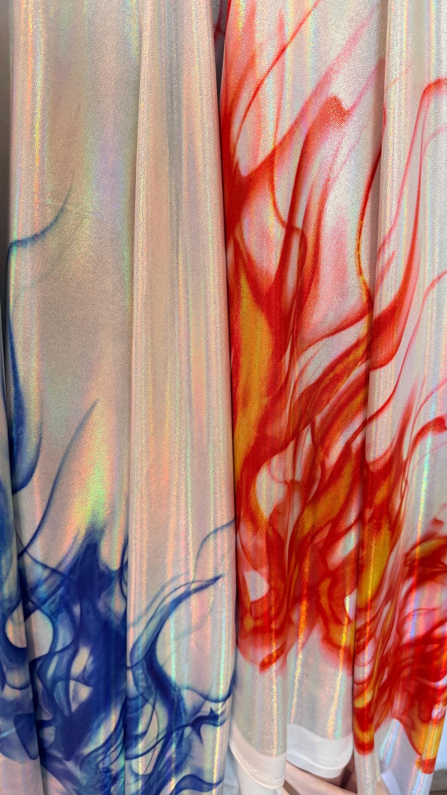 Flames design Black/Fire and White/Sapphire on Iridescent Hologram metallic nylon spandex 4-way stretch 58/60” Sold by the YD.