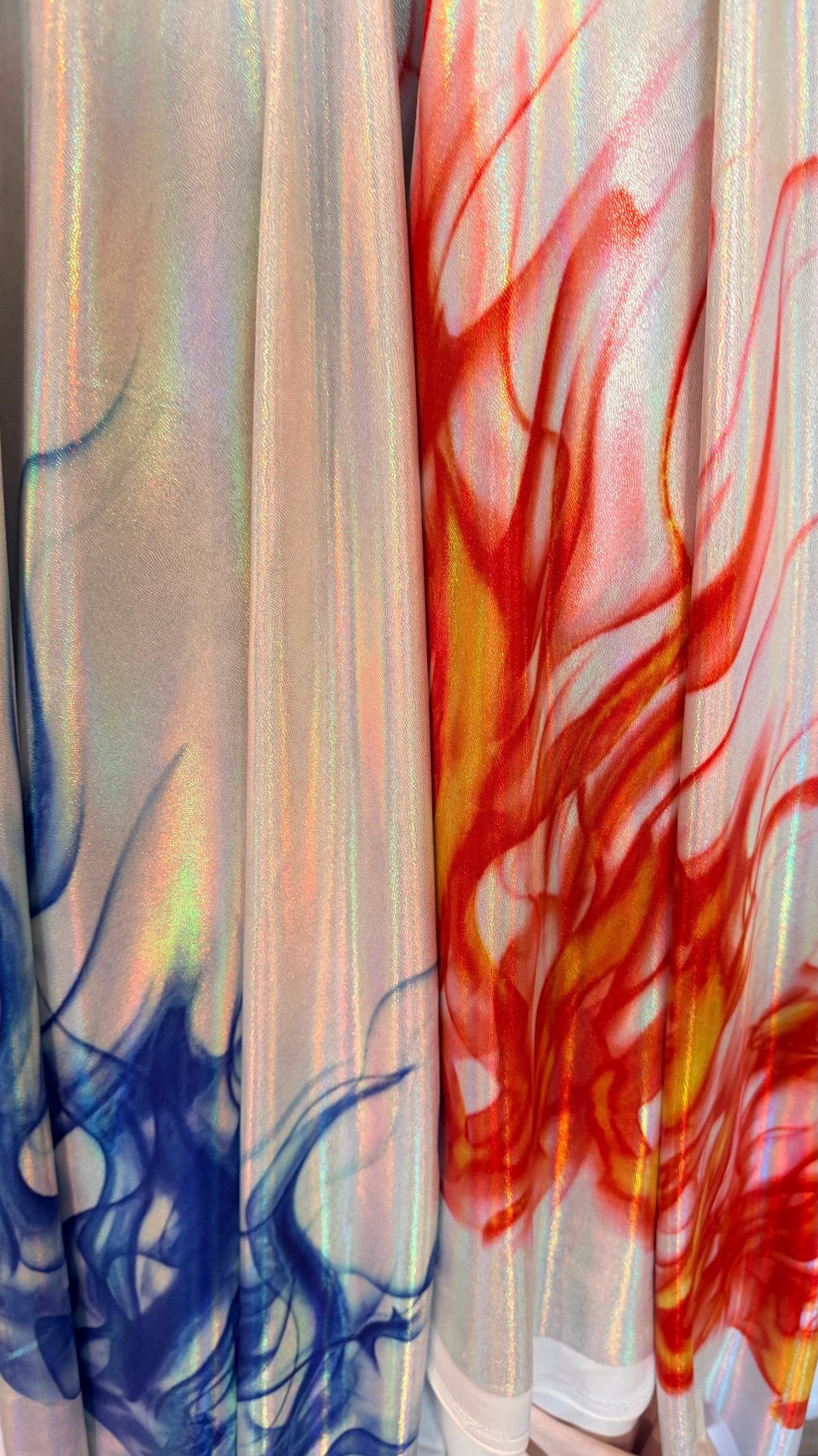 Flames design Black/Fire and White/Sapphire on Iridescent Hologram metallic nylon spandex 4-way stretch 58/60” Sold by the YD.