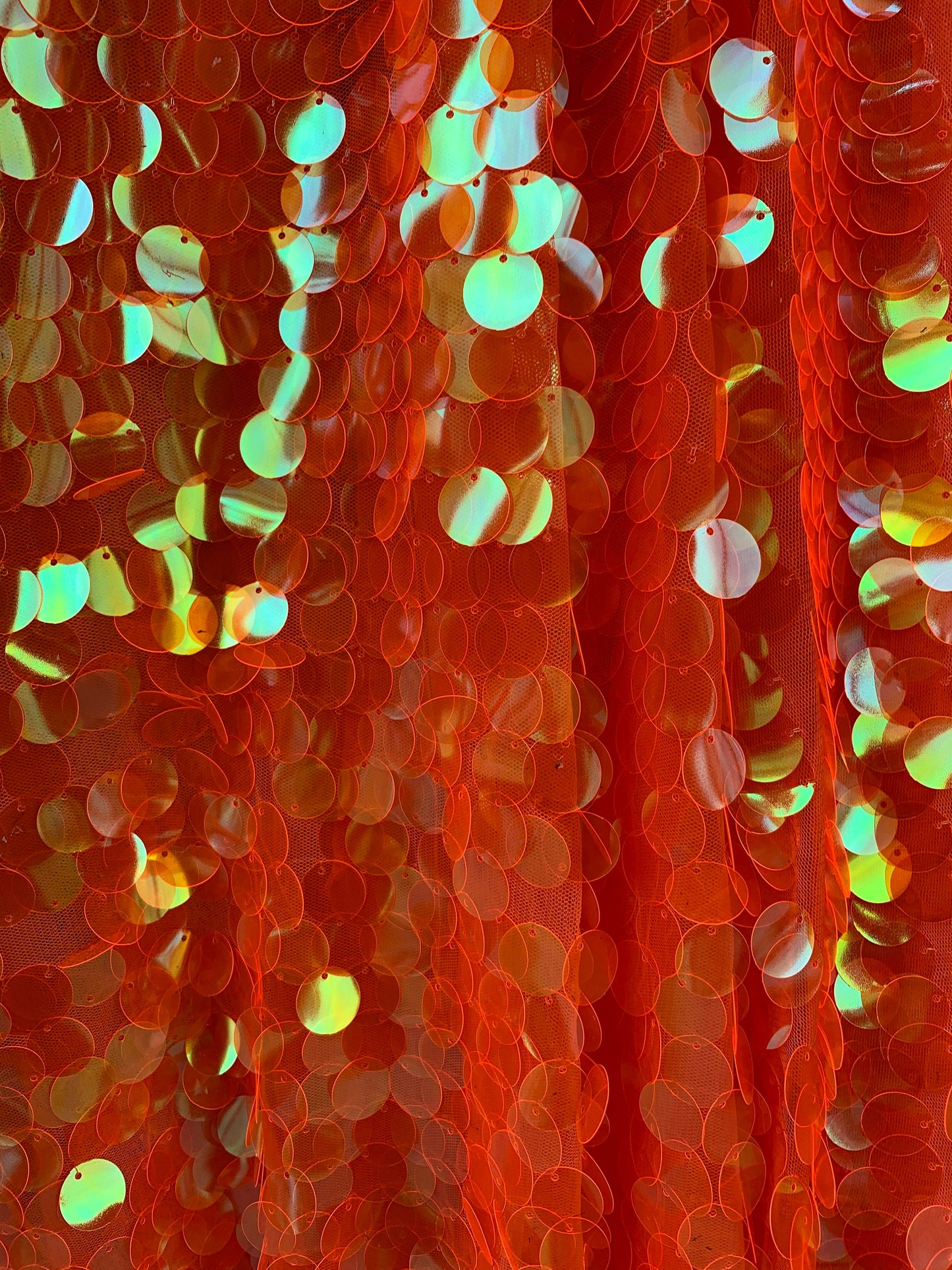 New Neon orange paillette sequins Iridescent orange 20mm size round sequins on stretch mesh 2-way 58/60” Sold by the YD. Ships worldwide.