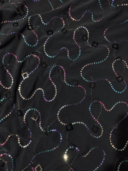 New poly black spandex with hanging iridescent sequins 2-way stretch 58/60” Sold by the YD. Ships worldwide from Los Angeles California USA.