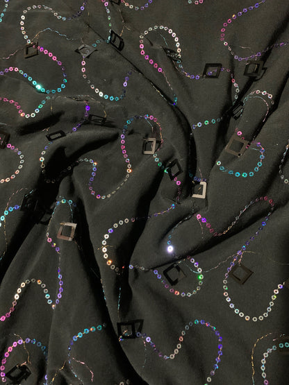 New poly black spandex with hanging iridescent sequins 2-way stretch 58/60” Sold by the YD. Ships worldwide from Los Angeles California USA.