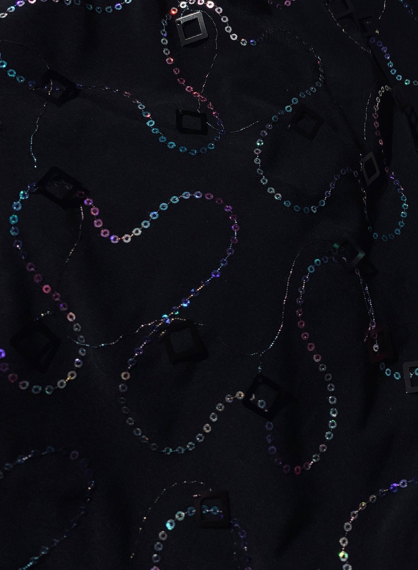 New poly black spandex with hanging iridescent sequins 2-way stretch 58/60” Sold by the YD. Ships worldwide from Los Angeles California USA.