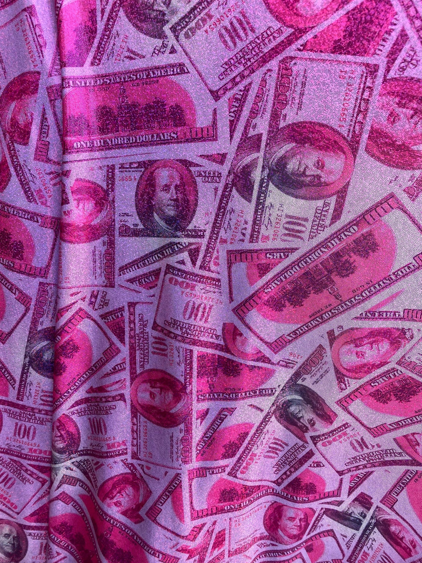 New metallic nylon spandex money design 100 dollar bill pink/green print on 4-way spandex with foggy foil all over 58/60” Sold by the YD.