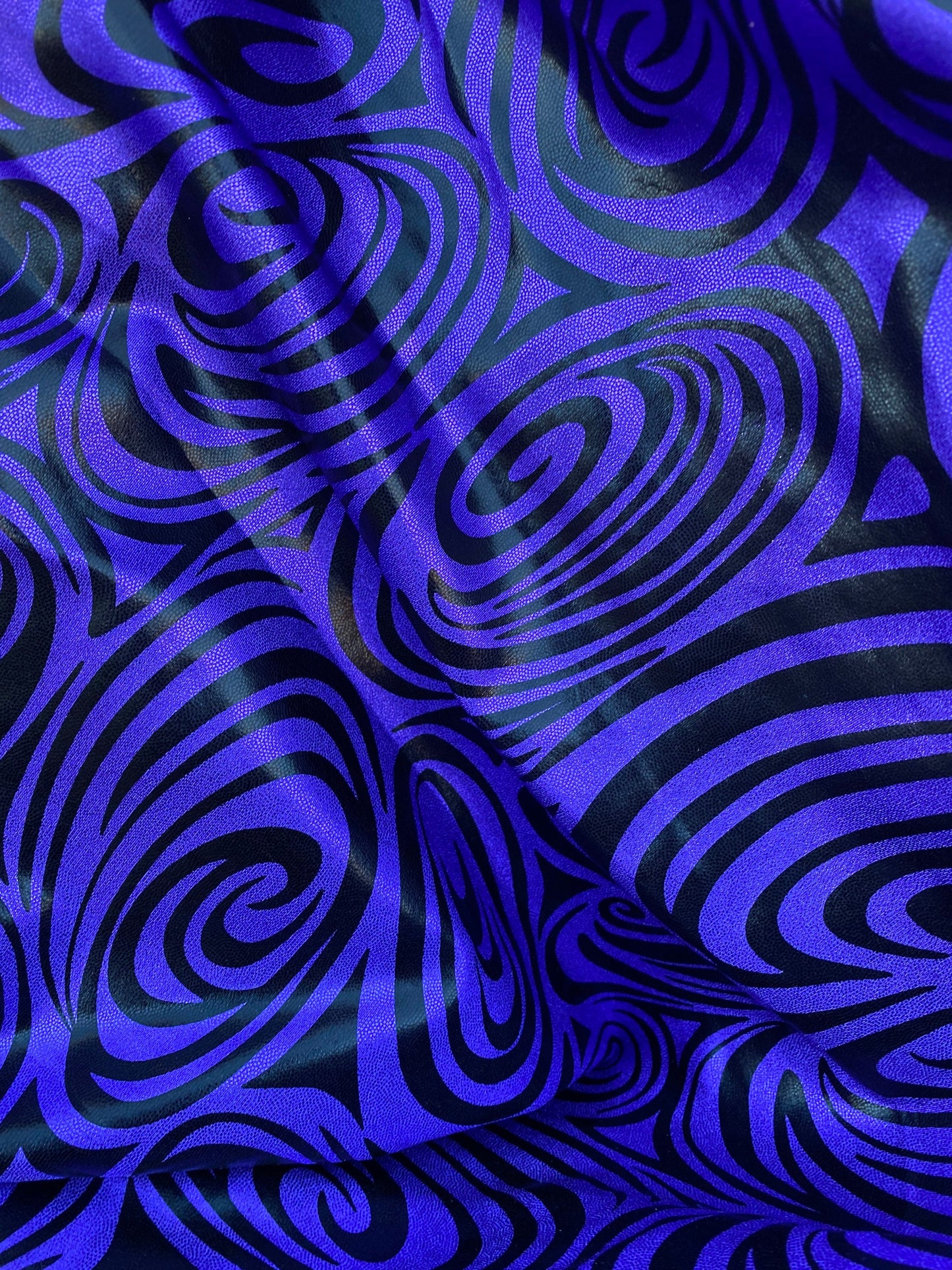 Swirl design print on purple foggy foil metallic nylon spandex 4-way stretch 58/60” Sold by the YD. Ships Worldwide from L.A