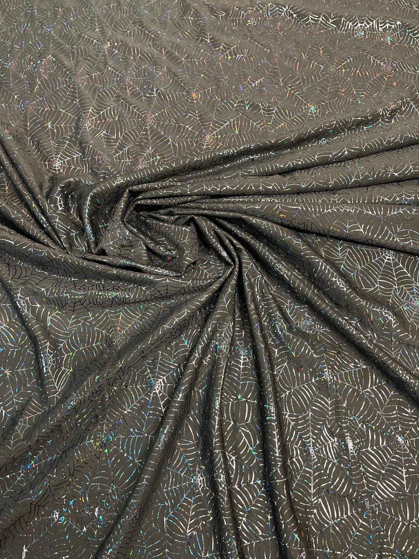 Spiderweb design black/black hologram nylon spandex 4-way stretch 58/60” Sold by the YD. Ships Worldwide from Los Angeles California USA.