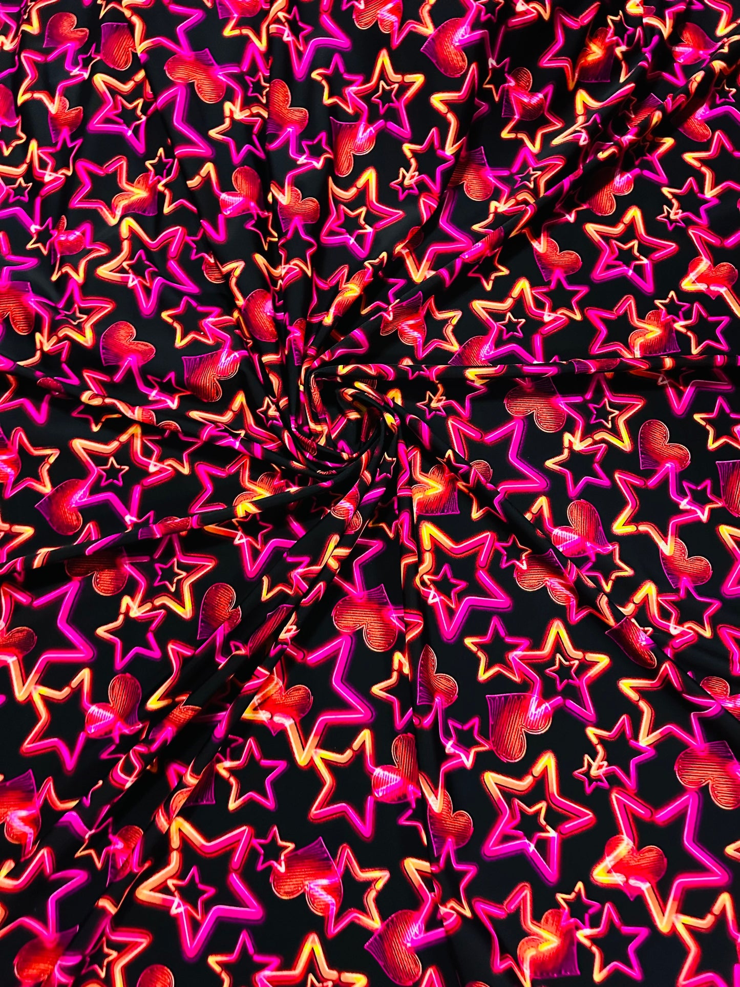 Stars design Black/Pink/Orange luxury design it glows in the dark with black light 4-way stretch nylon spandex 58/60” Sold by the YD.