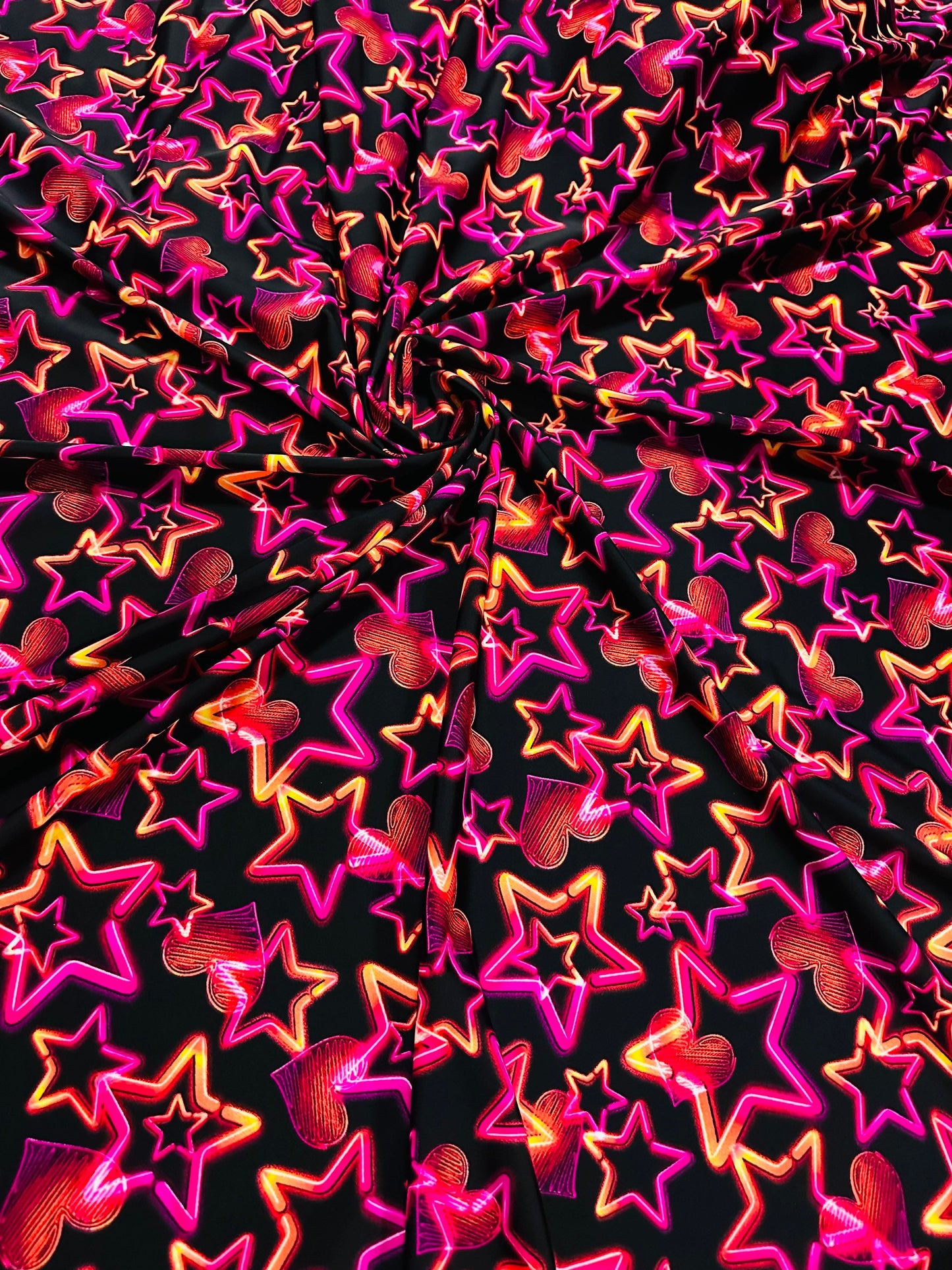 Stars design Black/Pink/Orange luxury design it glows in the dark with black light 4-way stretch nylon spandex 58/60” Sold by the YD.